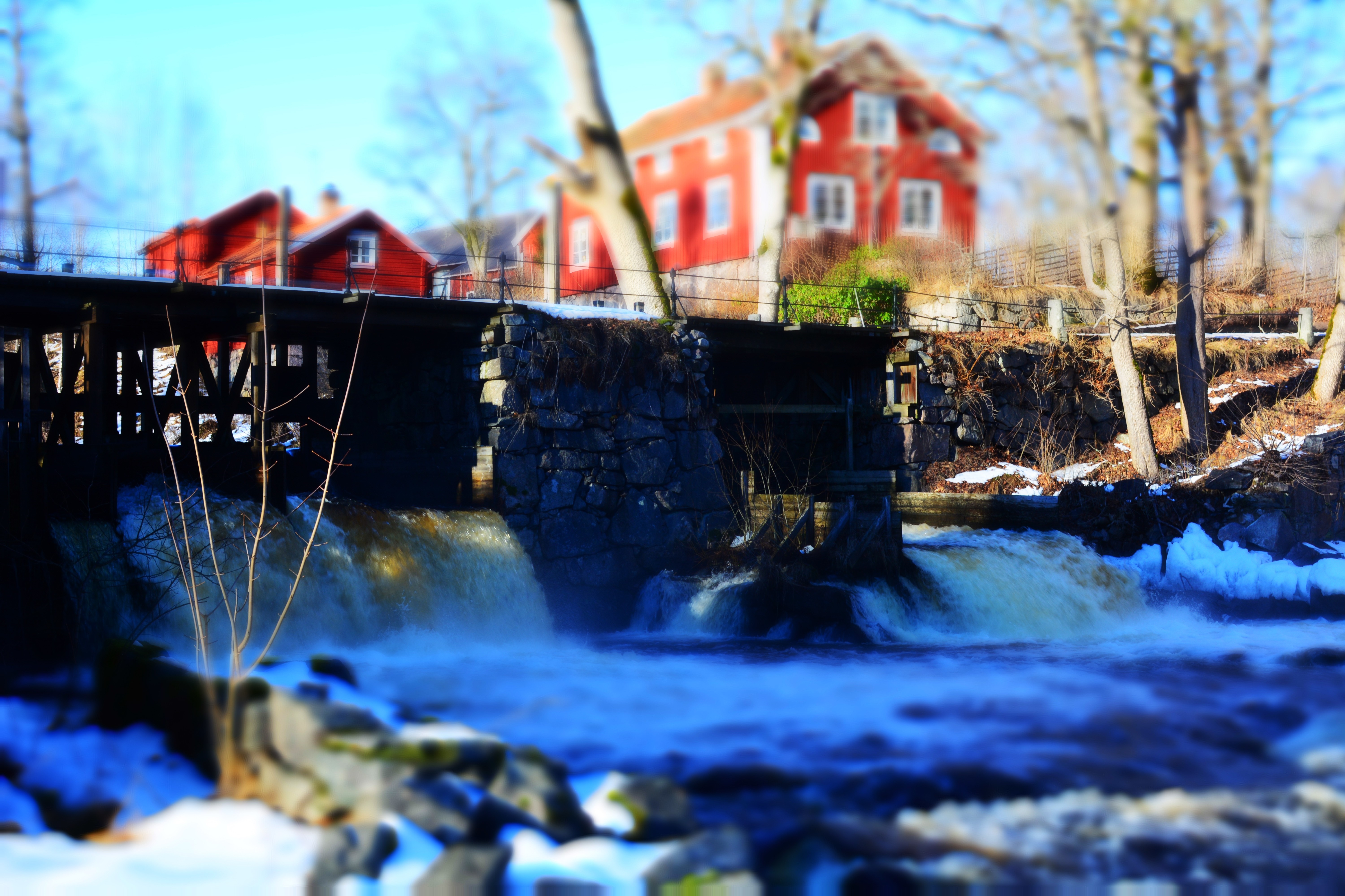 Red houses and a bridge over a waterfall in winter HD Wallpaper