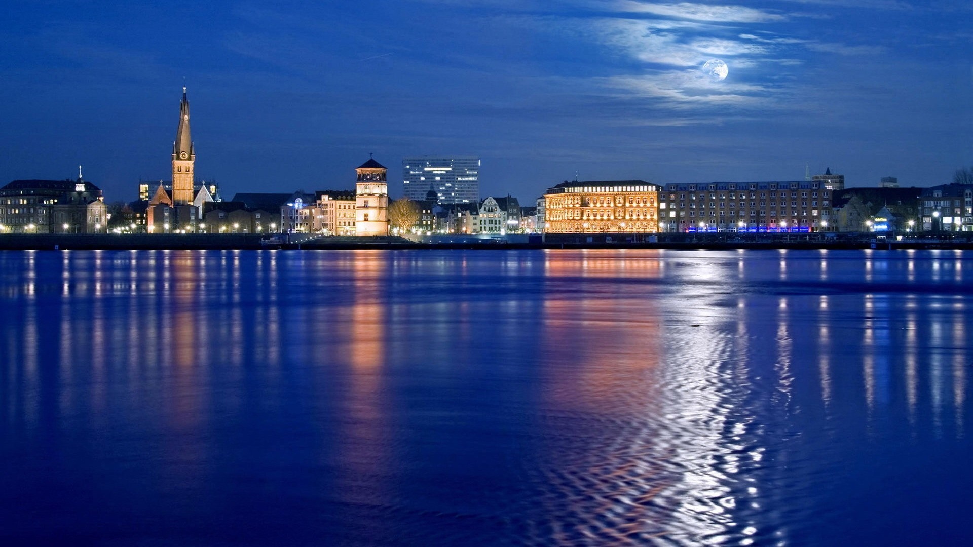 City skyline reflected in water at night HD Wallpaper