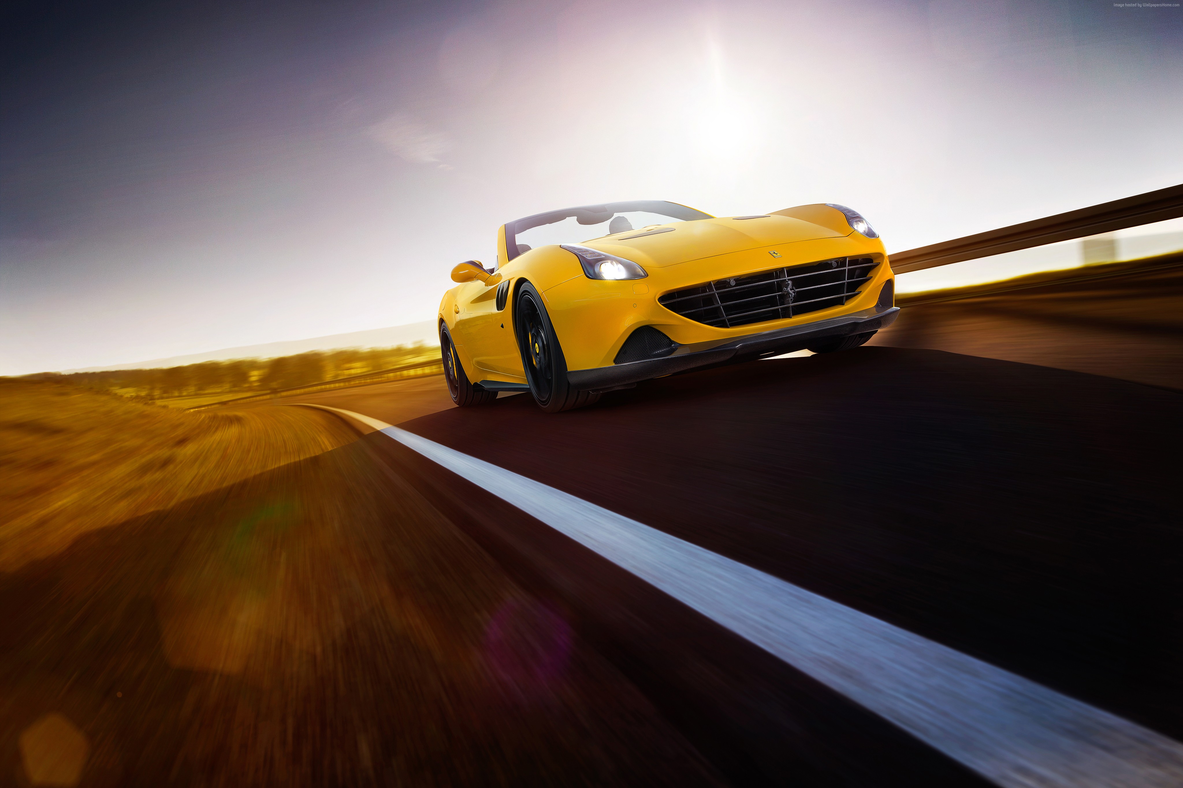 Yellow Ferrari California T driving on a road HD Wallpaper