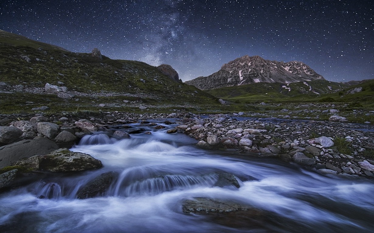 Mountain stream under a starry night sky HD Wallpaper
