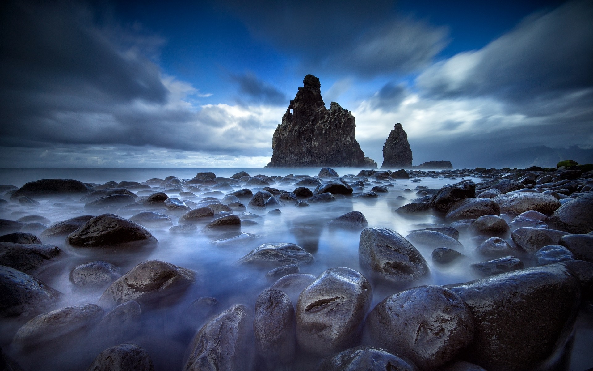 Rocky shore with sea stacks under cloudy sky HD Wallpaper