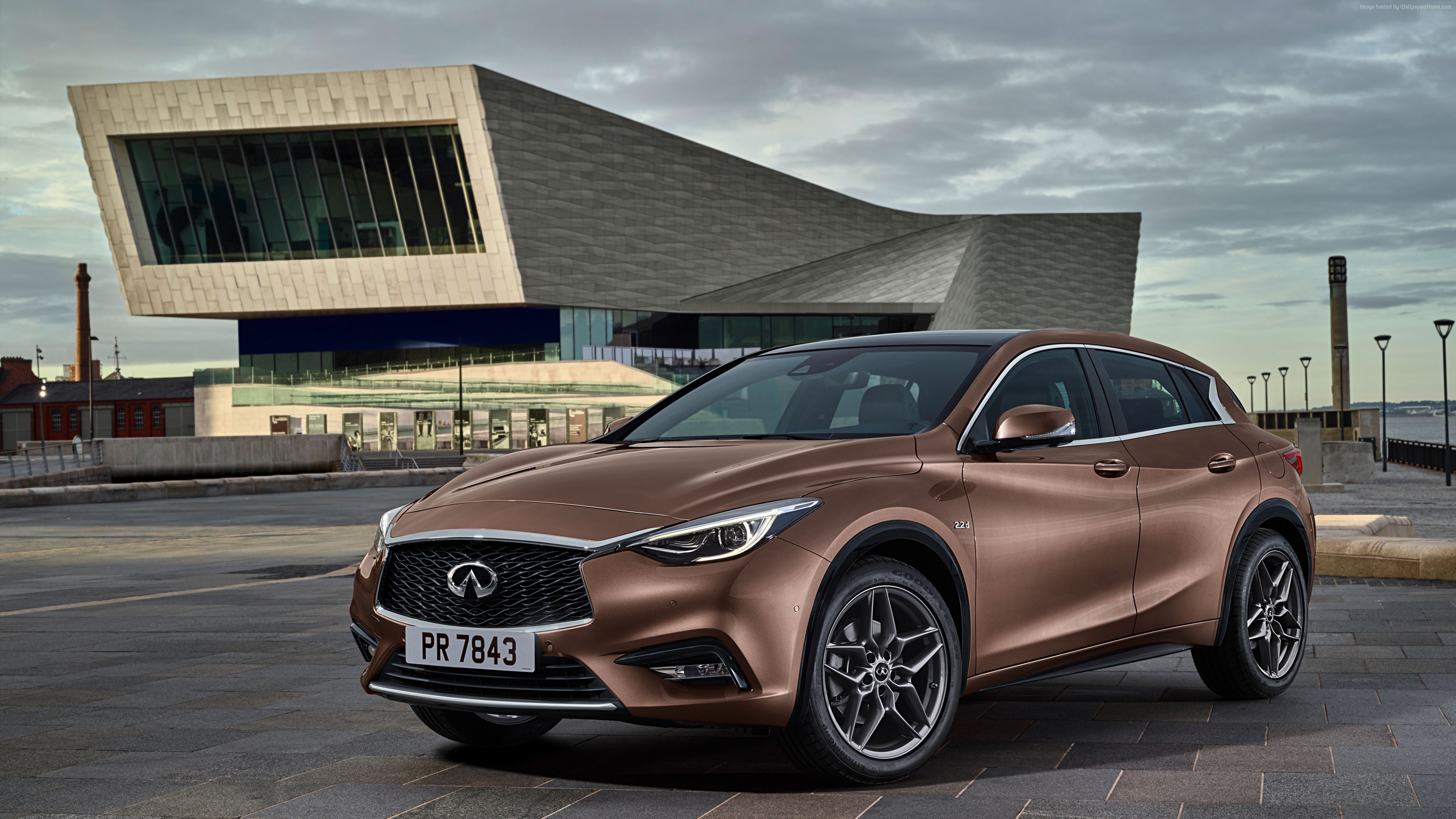 Brown Infiniti Q30 parked in front of a modern building HD Wallpaper
