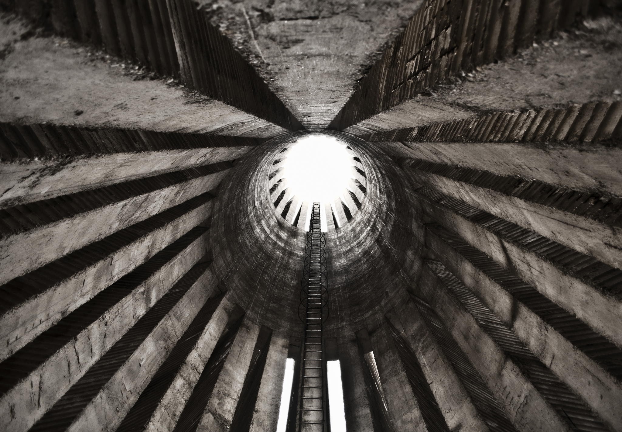 Monochrome view inside a concrete structure with a ladder HD Wallpaper