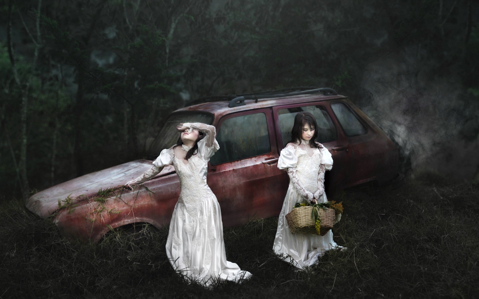Two women in white dresses near a derelict car HD Wallpaper