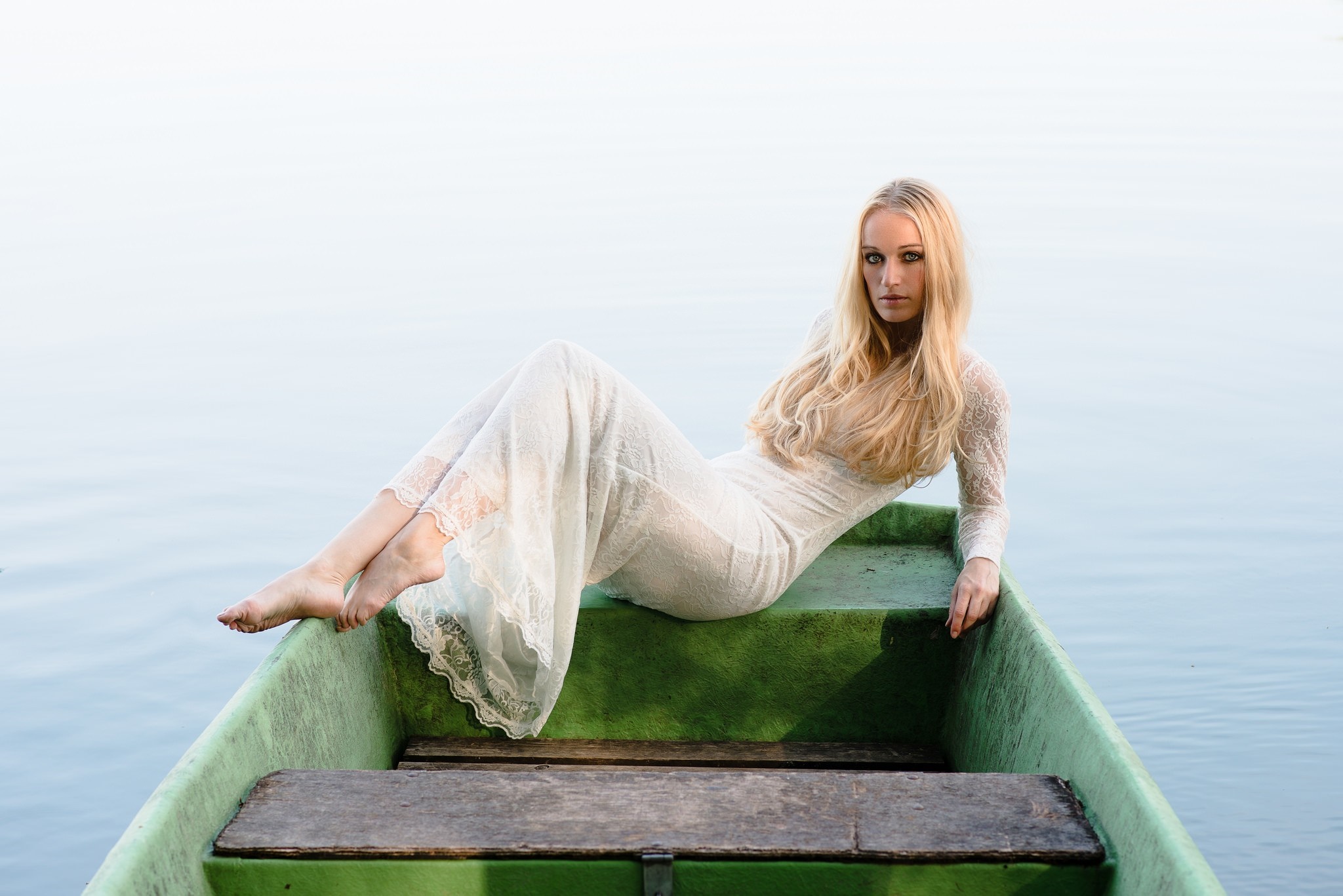 Woman in white dress sitting in a green boat on water HD Wallpaper