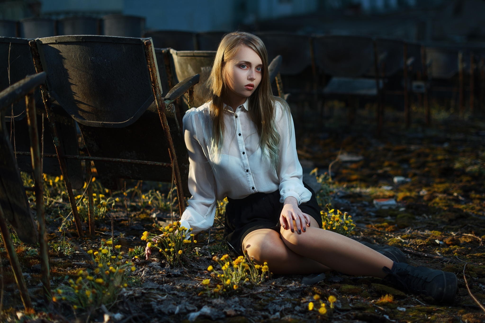 Woman sitting in abandoned theater with yellow flowers HD Wallpaper