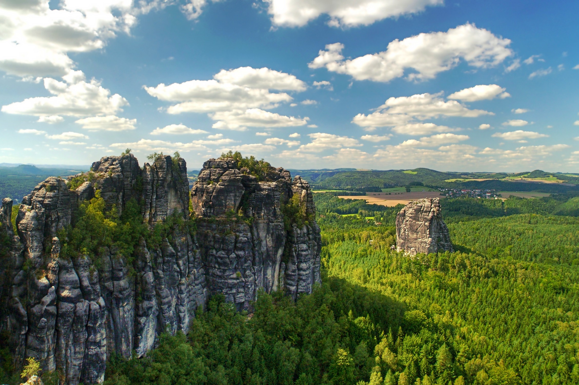 Majestic Rocky Cliffs Above Dense Green Forest HD Wallpaper