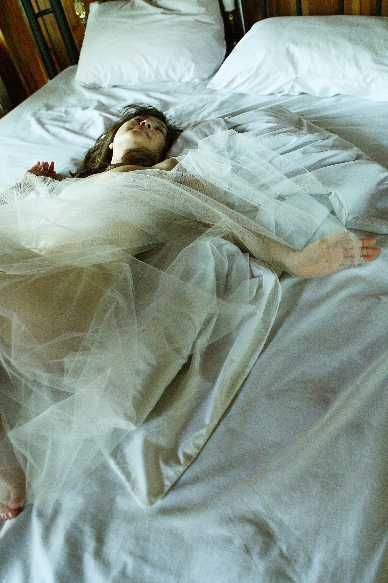 Woman in white dress sleeping on a bed HD Wallpaper