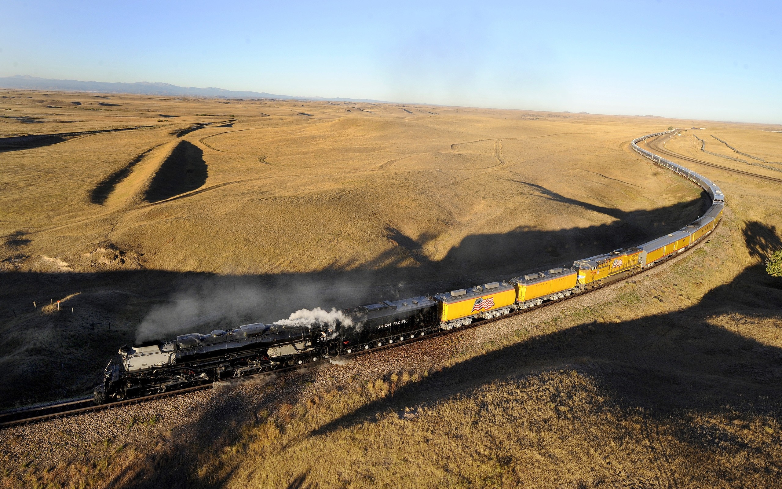 Union Pacific steam locomotive and yellow train cars on a track HD Wallpaper