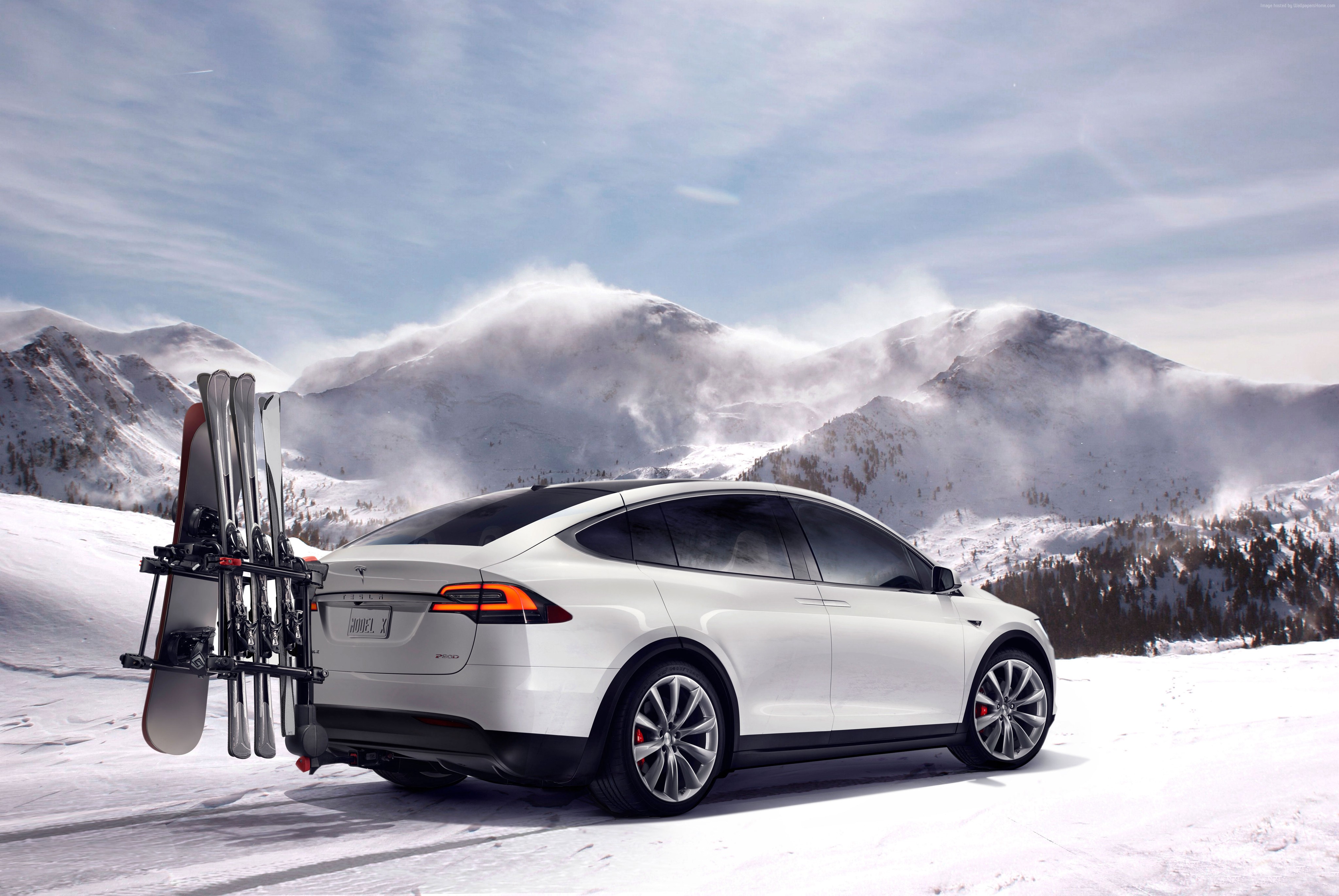White Tesla Model X with skis and snowboard in snowy mountains HD Wallpaper