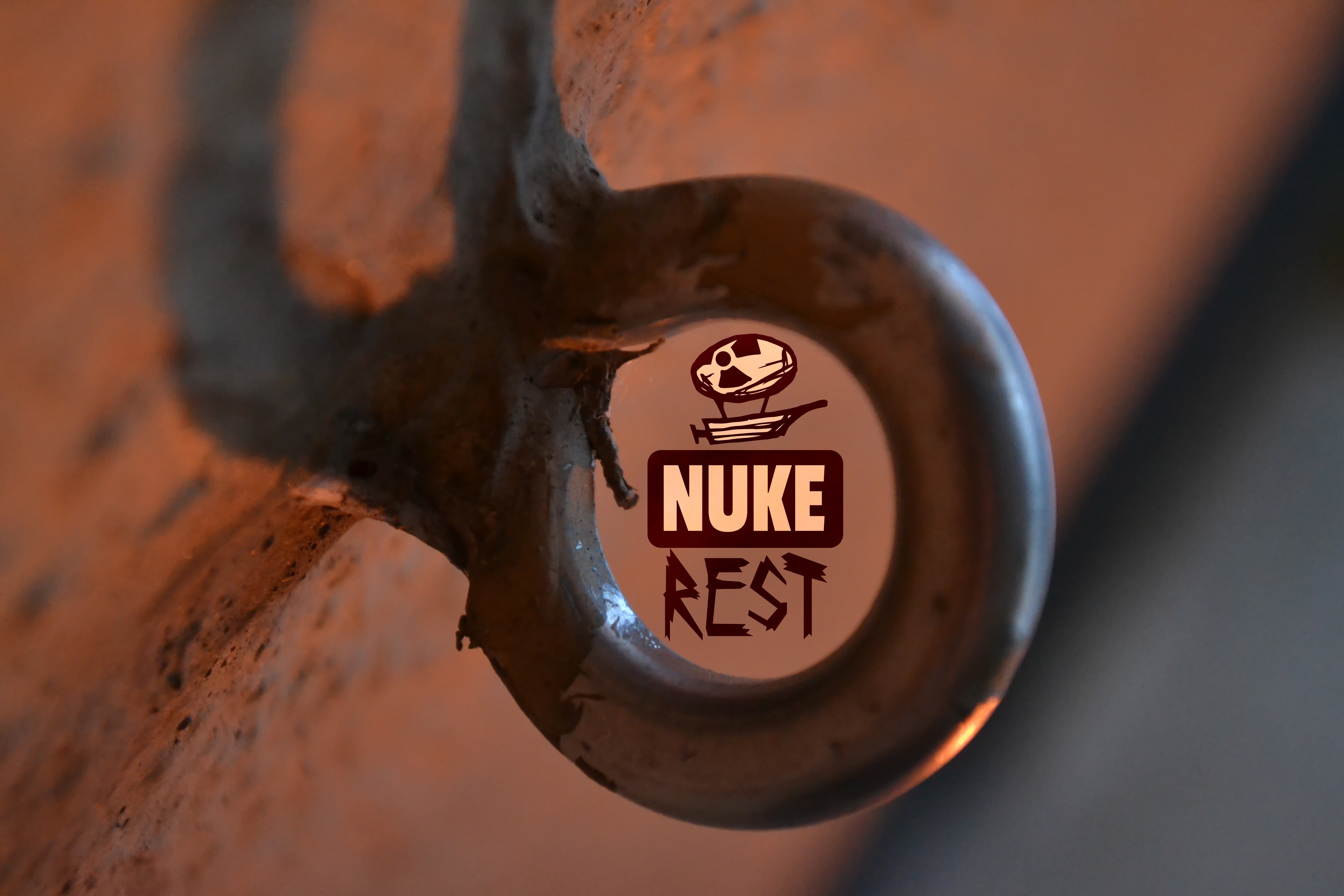 Close up of a metal eye bolt with a logo HD Wallpaper