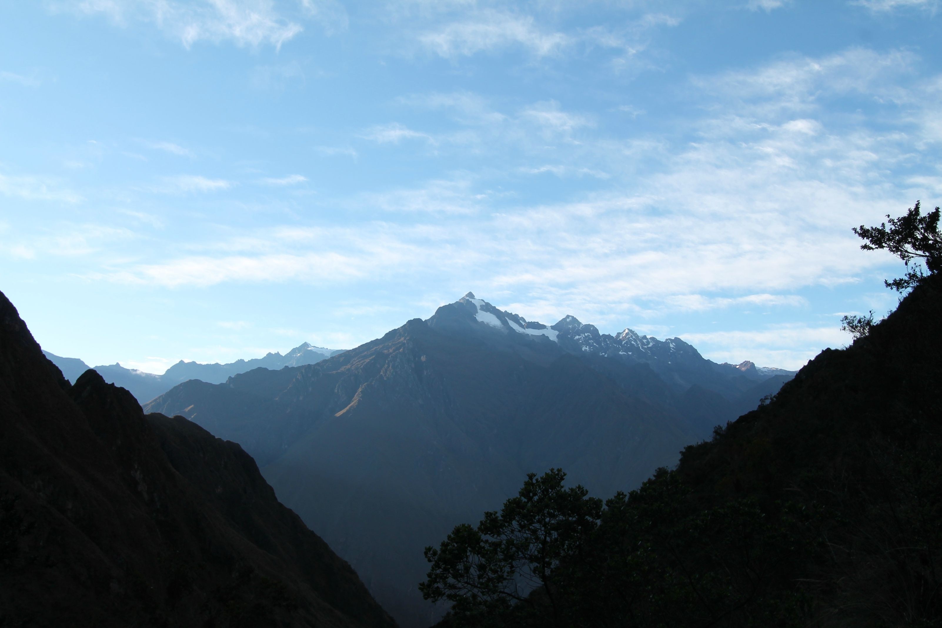 Snow-capped mountains under a cloudy blue sky HD Wallpaper