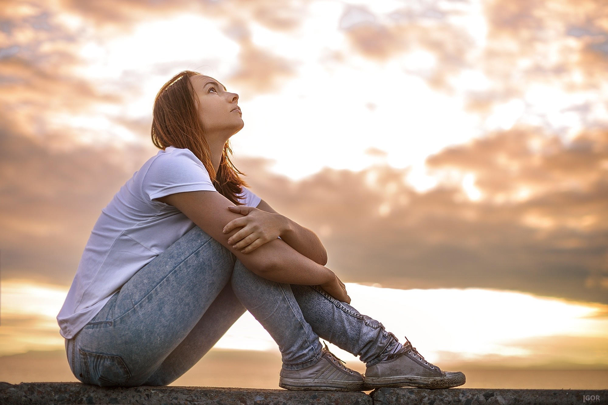Woman sitting on a ledge at sunset HD Wallpaper