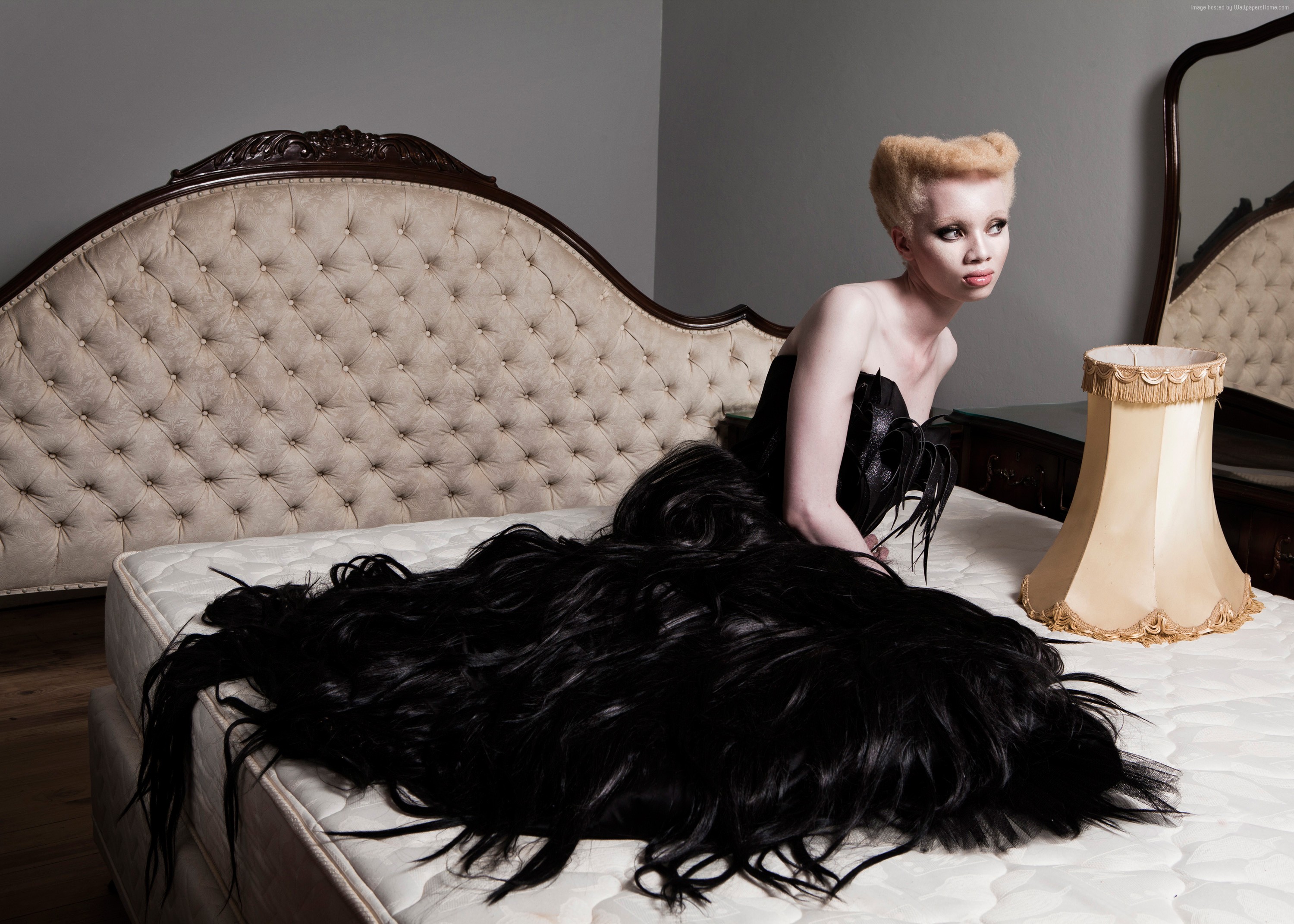 Julia Daka on a bed with a large black wig HD Wallpaper