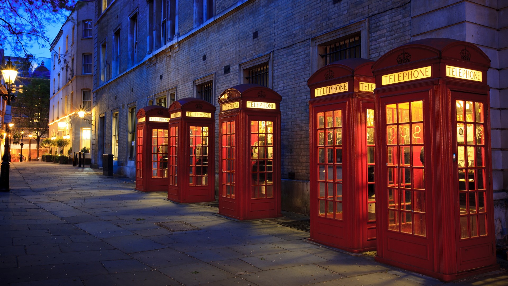 Red telephone boxes on a street at night HD Wallpaper