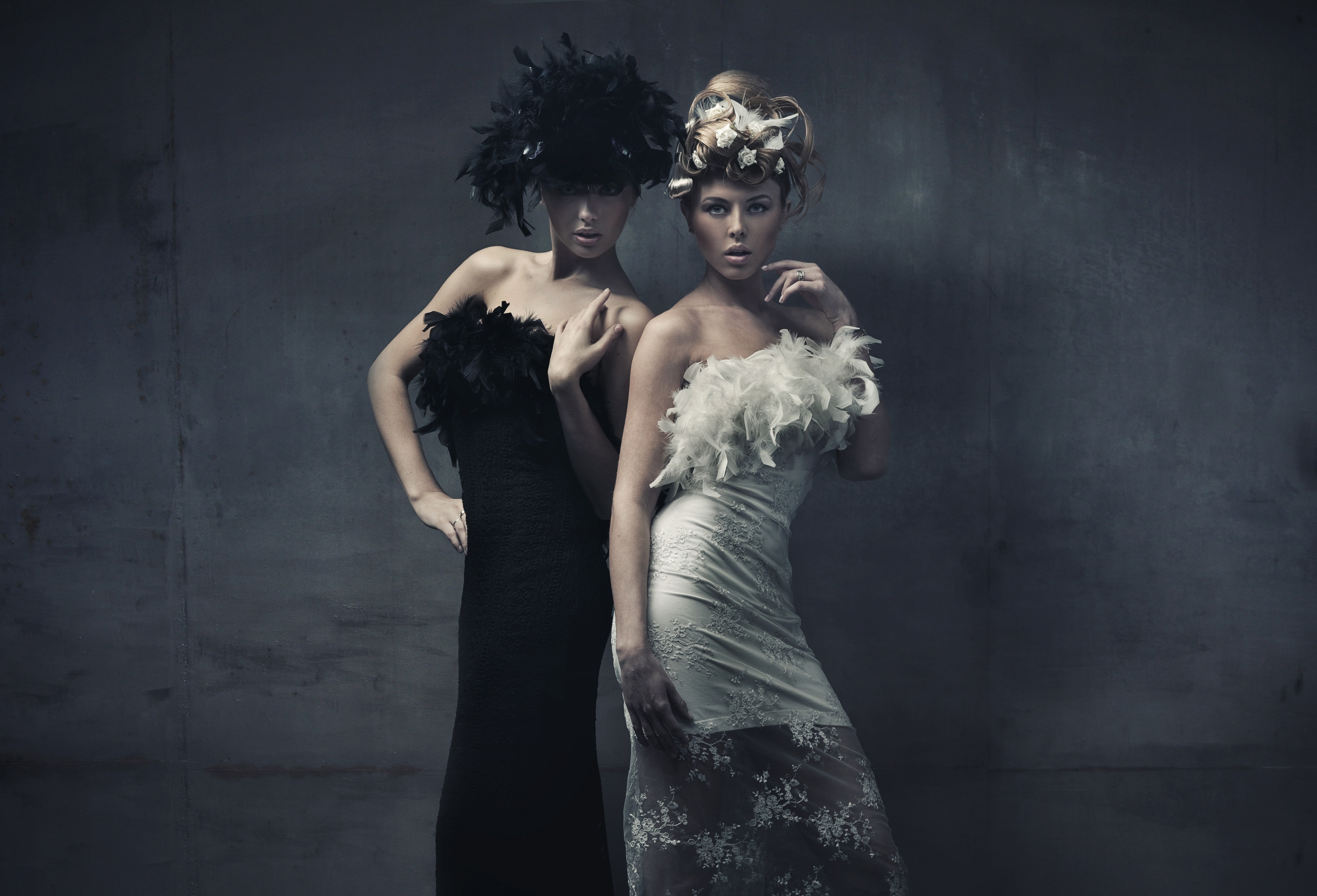 Two women in elegant dresses and elaborate headwear HD Wallpaper