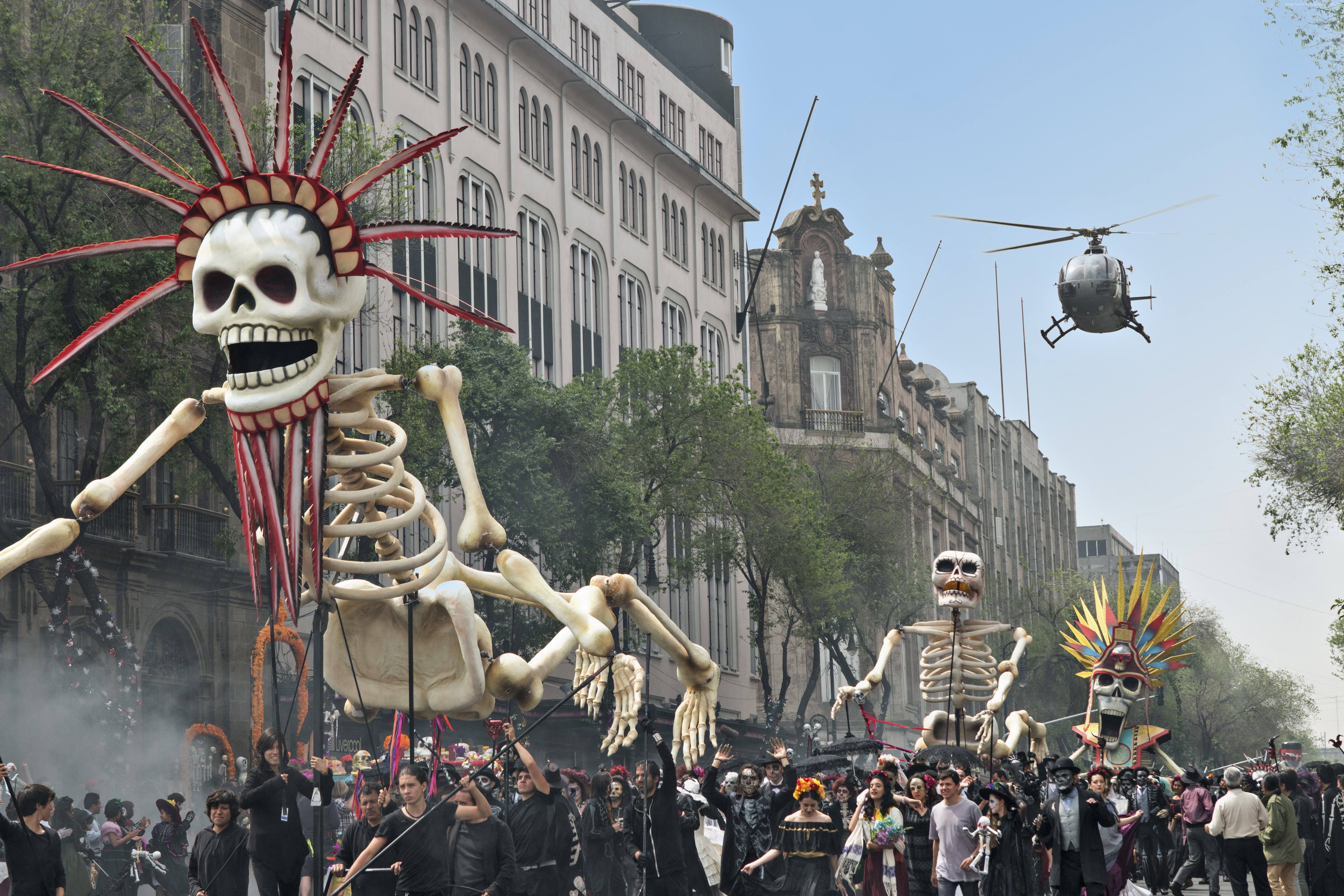 Day of the Dead parade with giant skeletons and helicopter HD Wallpaper