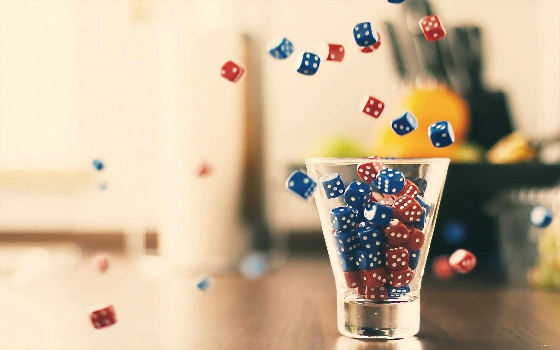 Red and blue dice falling into a glass HD Wallpaper
