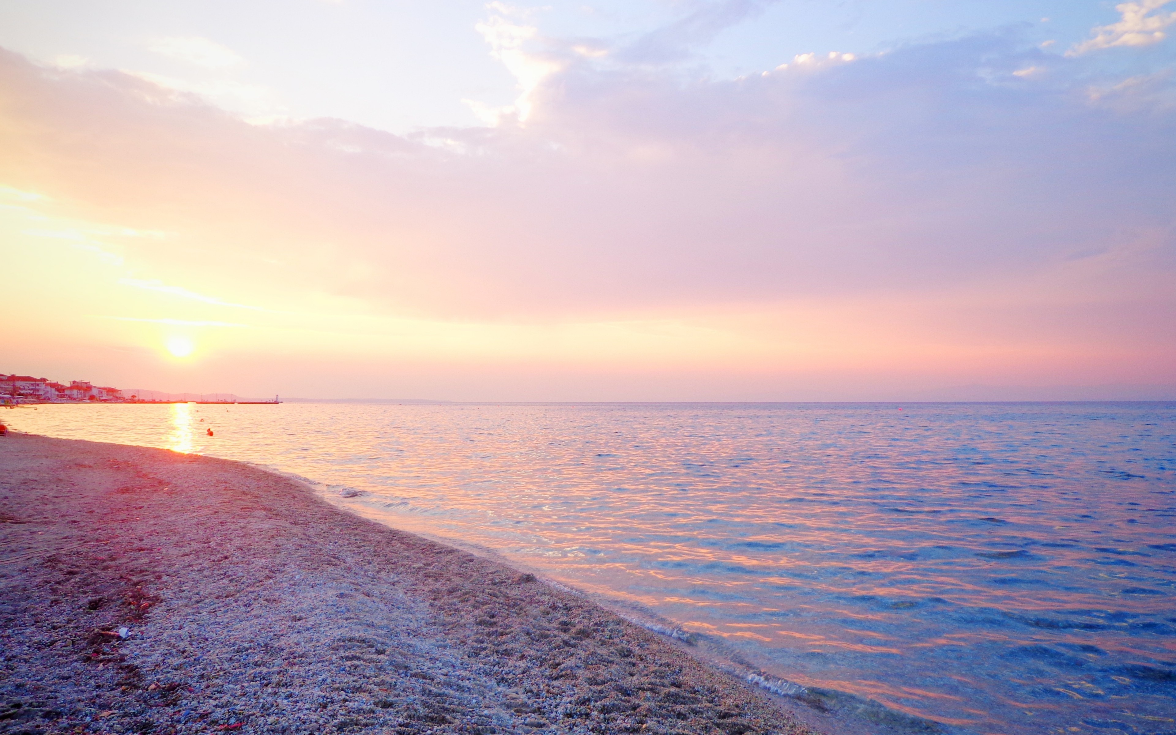 Sunset over the sea with a beach in the foreground HD Wallpaper