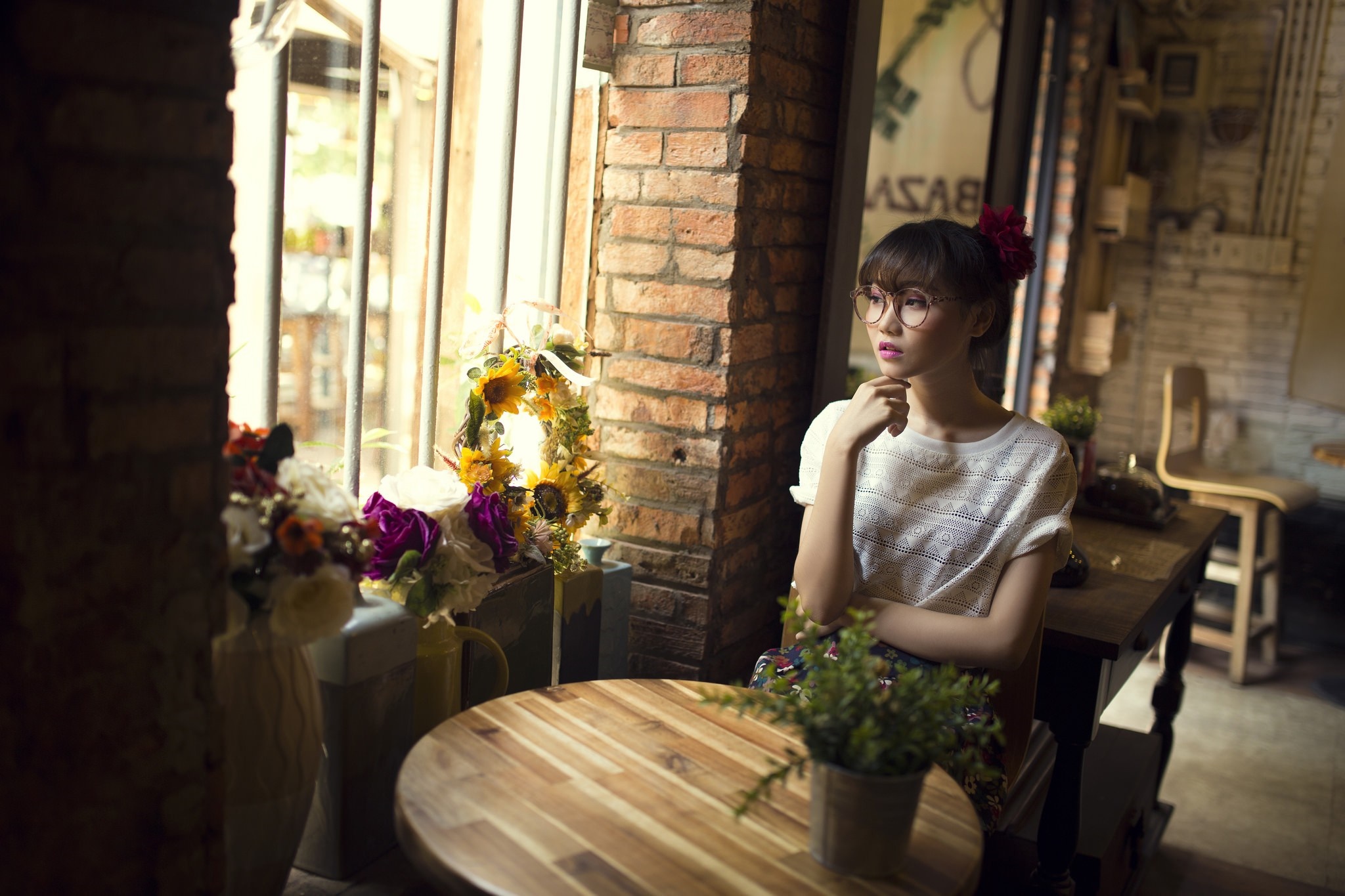 Woman with flower in hair sitting by window HD Wallpaper