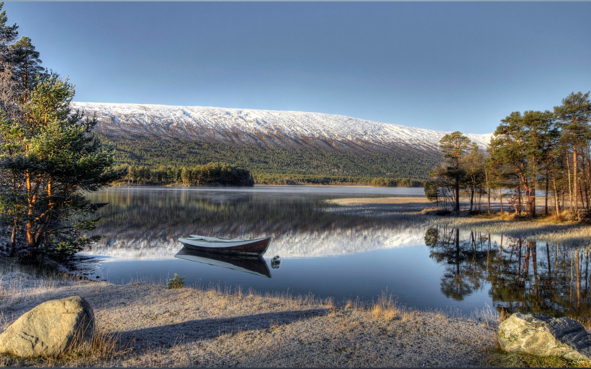 Boat on a calm lake with snow-capped mountains HD Wallpaper