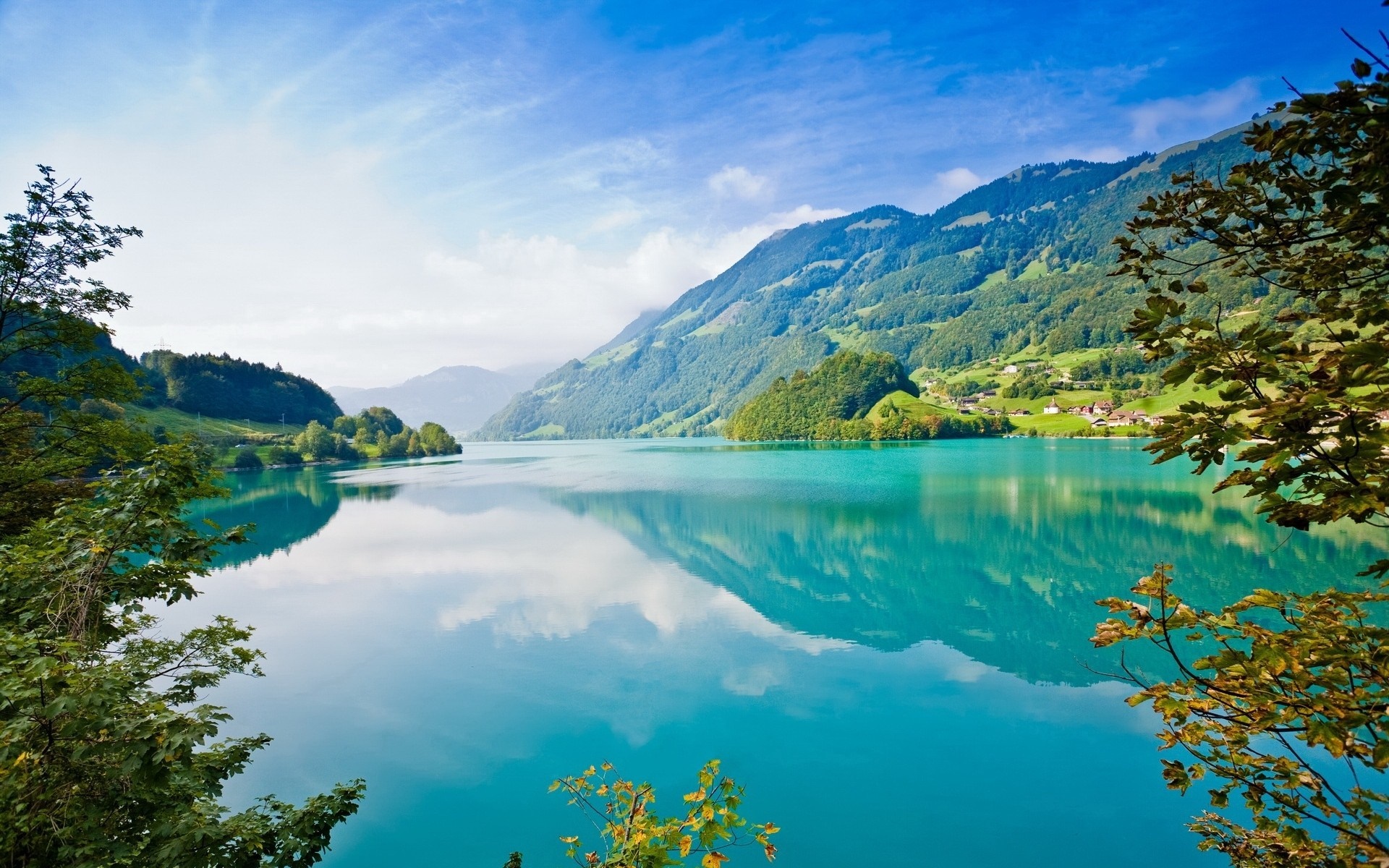 Turquoise lake reflecting mountains and trees under a blue sky HD Wallpaper