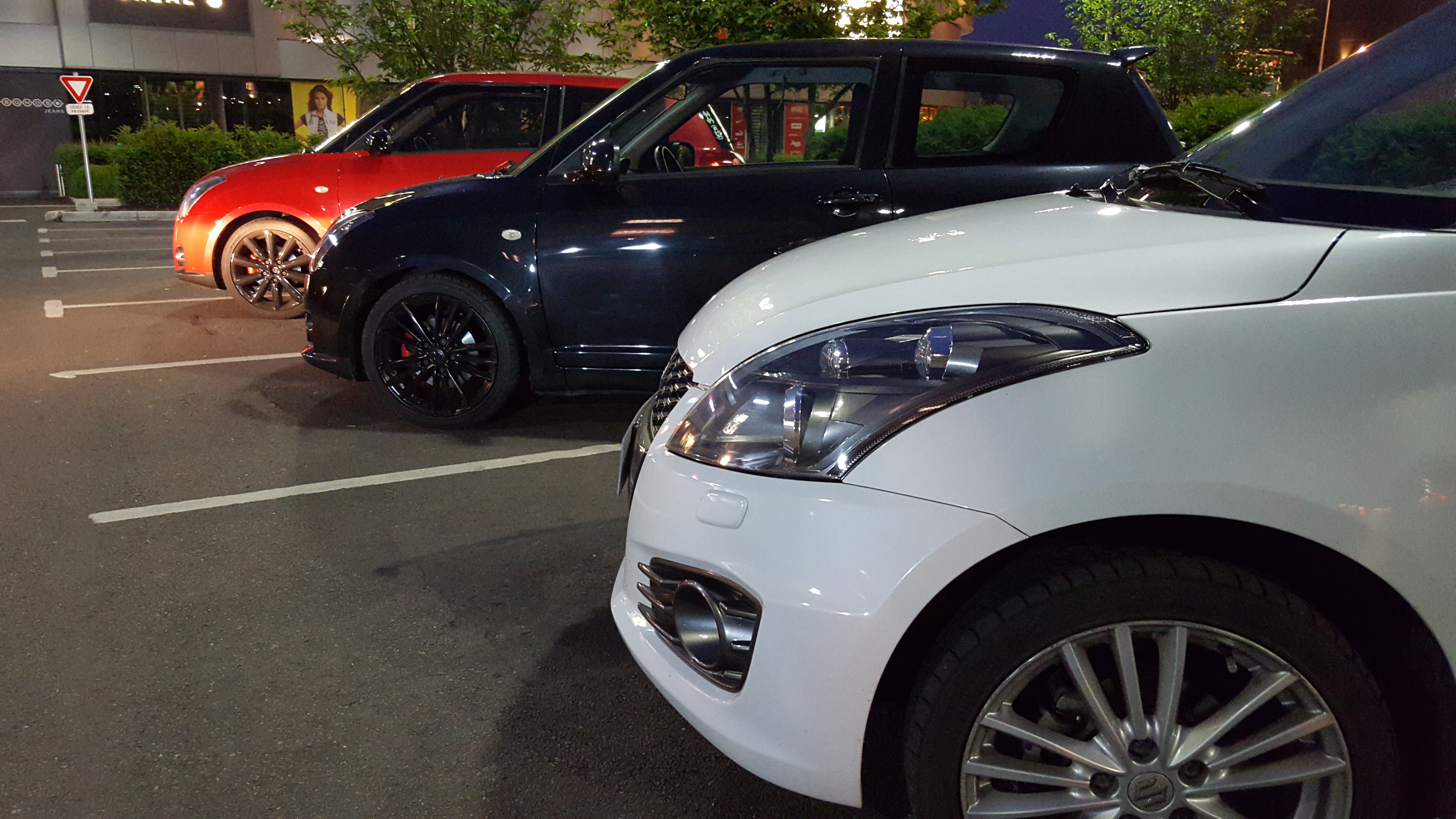 Three Suzuki Swift cars parked in a lot HD Wallpaper