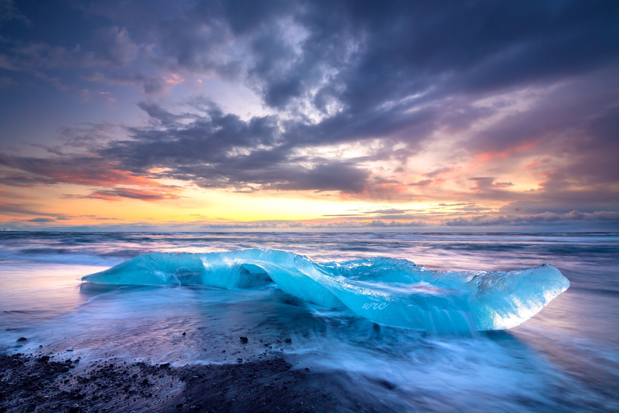 Iceberg on a black sand beach at sunset HD Wallpaper