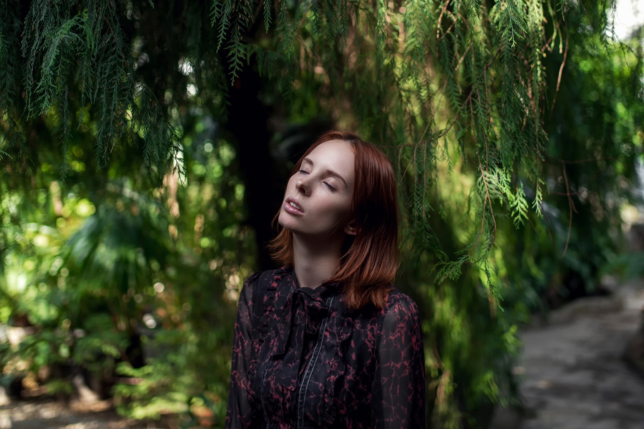 Woman with red hair in a dark floral dress in a garden HD Wallpaper