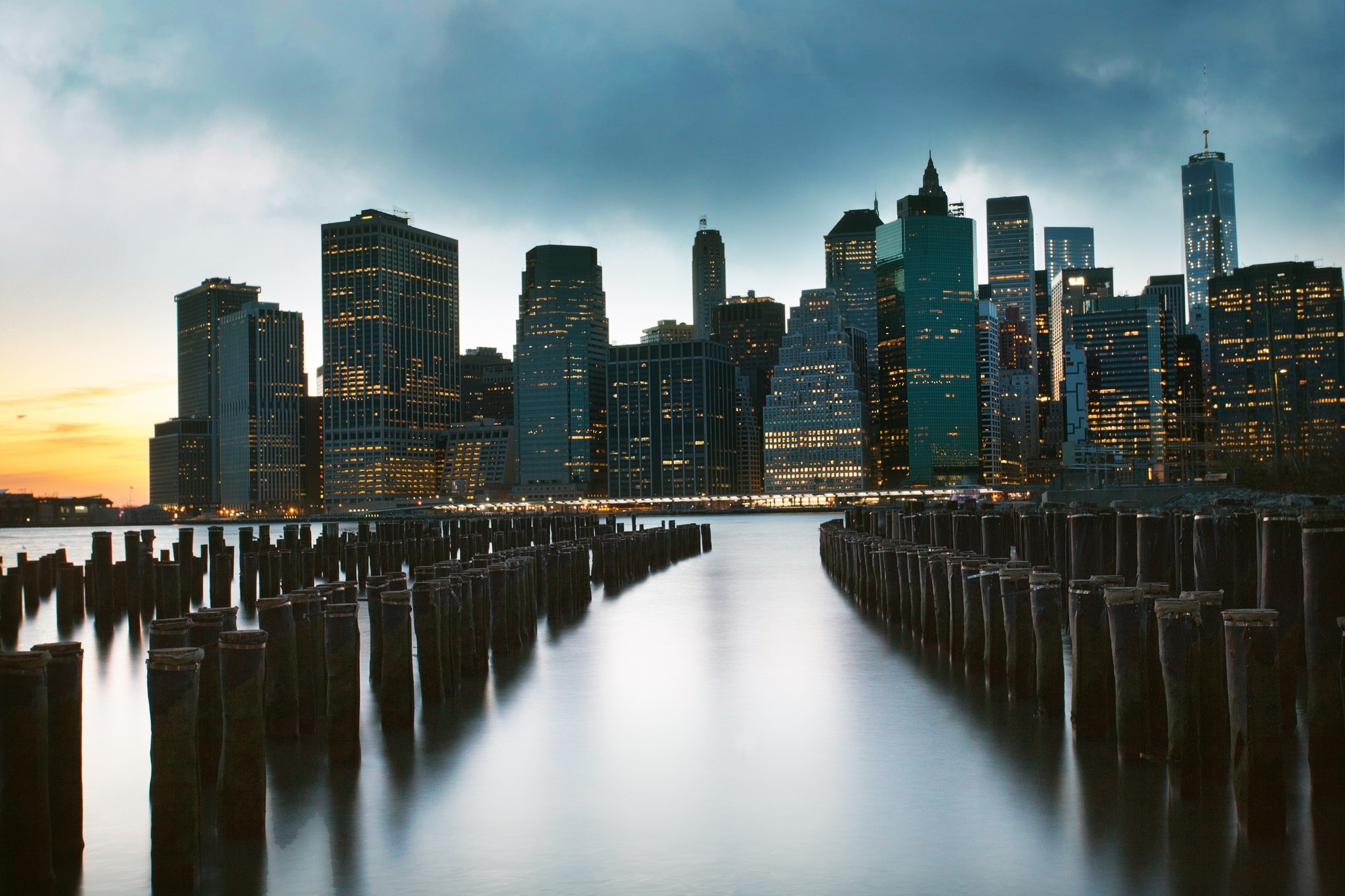 New York City skyline at dusk over the river with piers HD Wallpaper