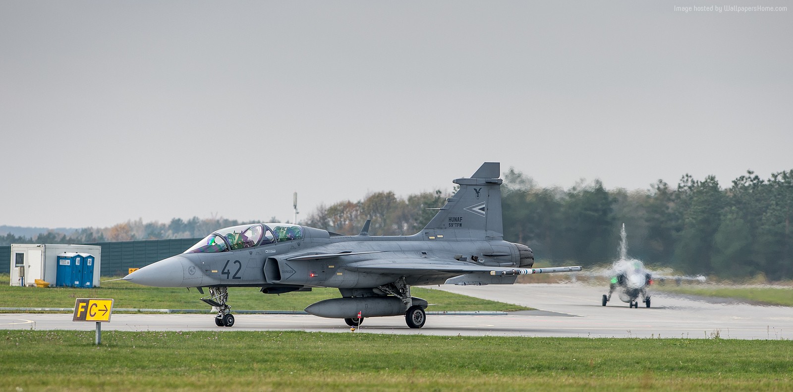 Two JAS 39D Gripen fighter jets on a runway HD Wallpaper