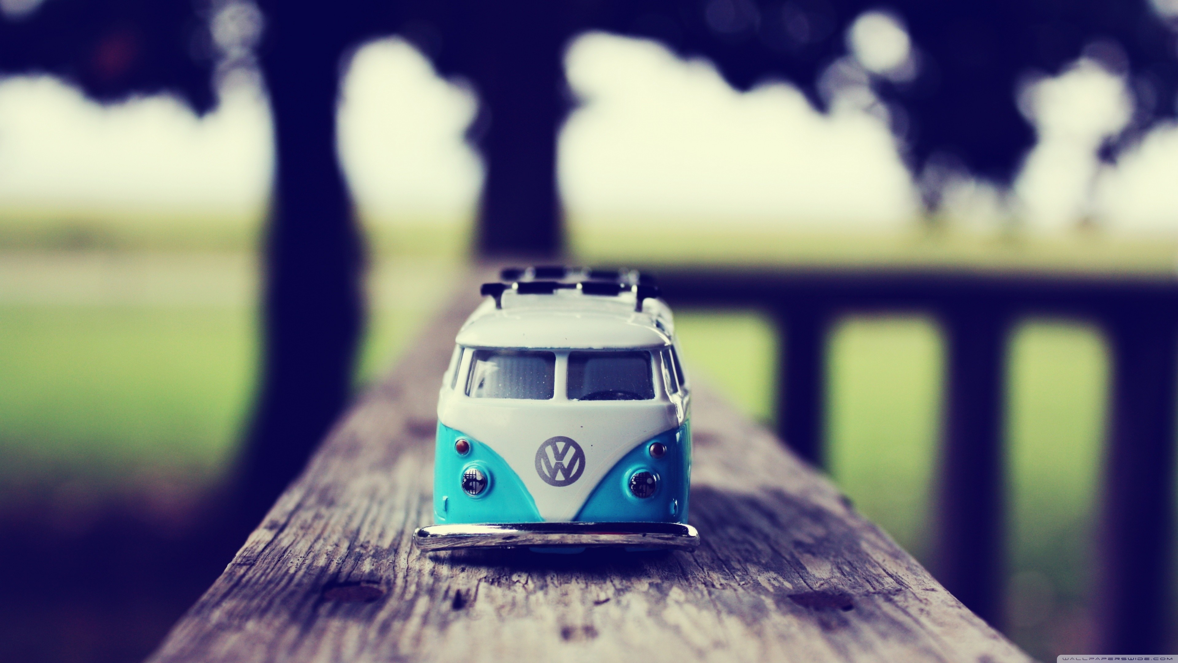 Blue and white Volkswagen bus toy on wooden surface HD Wallpaper