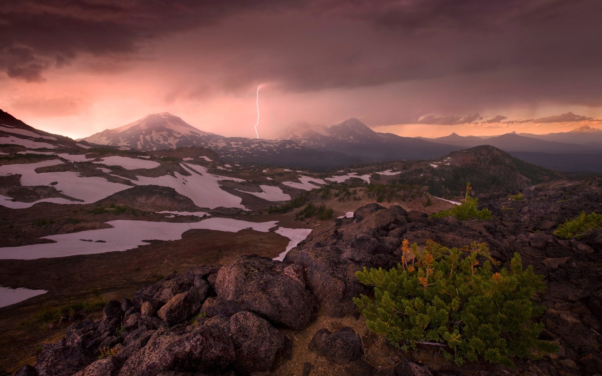 Lightning strikes over snowy mountains at sunset HD Wallpaper