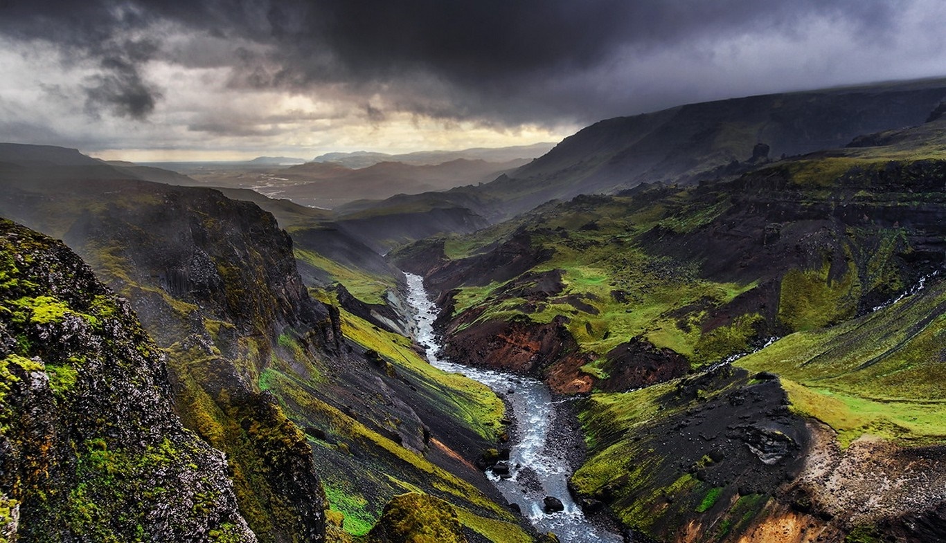 River flowing through a green canyon in Iceland under stormy clouds HD Wallpaper