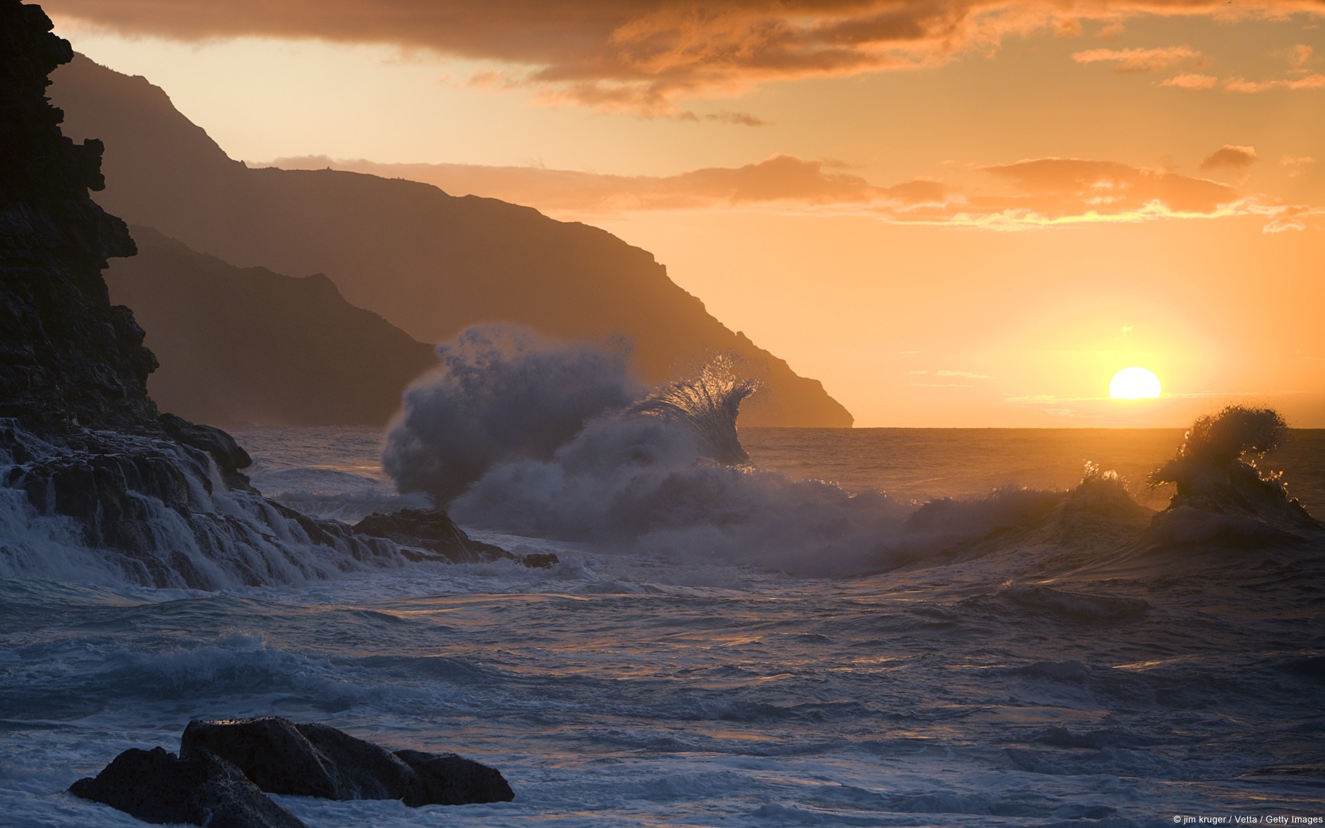 Waves crashing on rocky shore at sunset HD Wallpaper