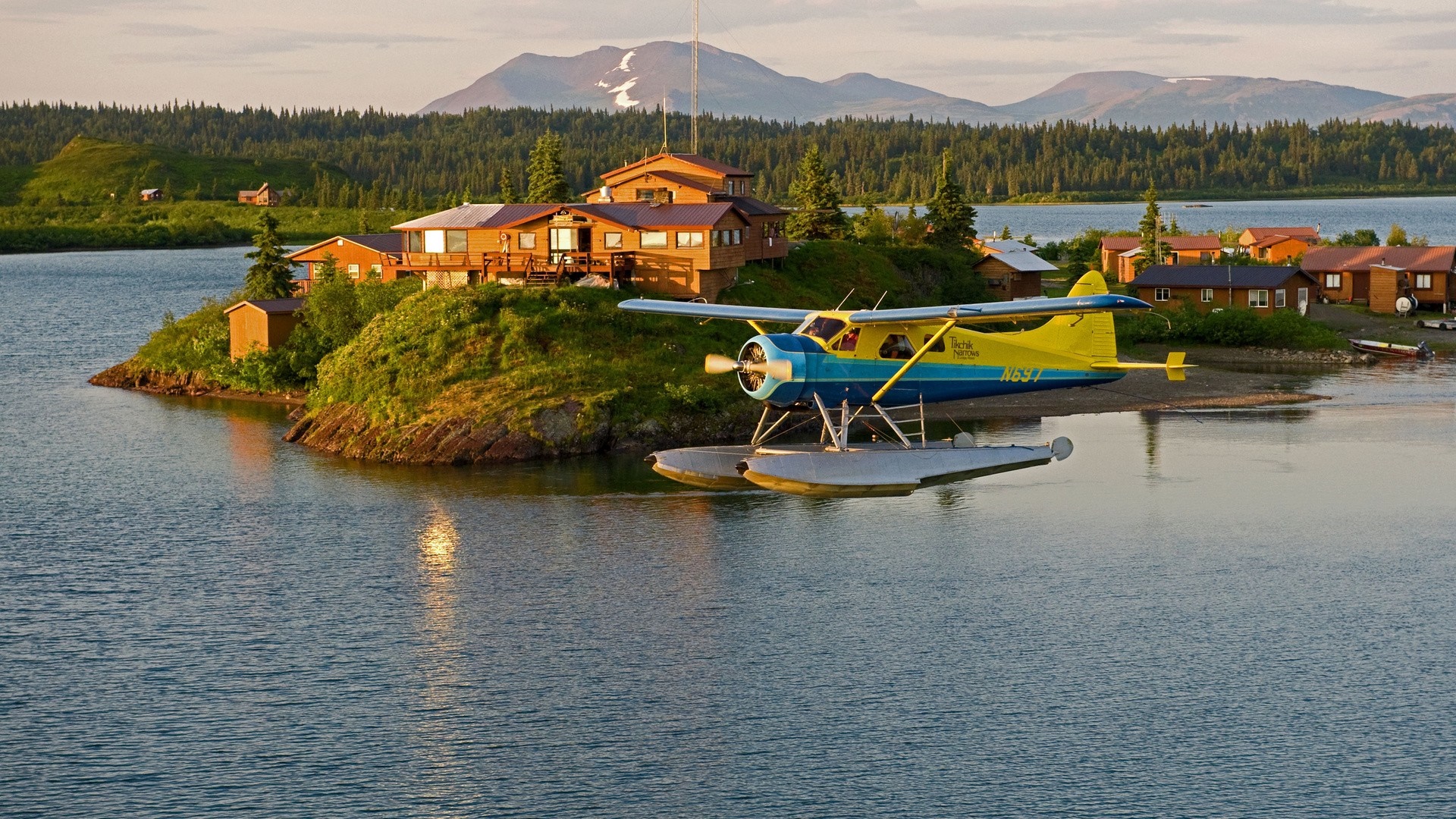 Floatplane at Alaskan lodge with mountains and forest HD Wallpaper
