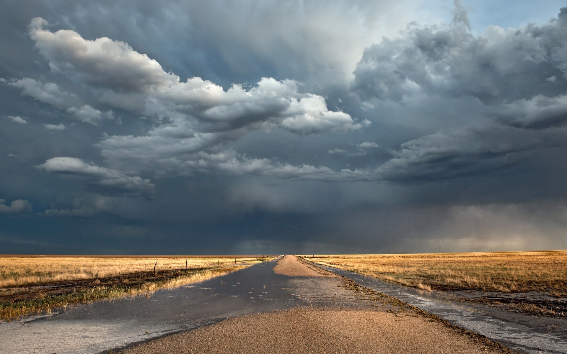 Stormy sky over a wet rural road and prairie HD Wallpaper