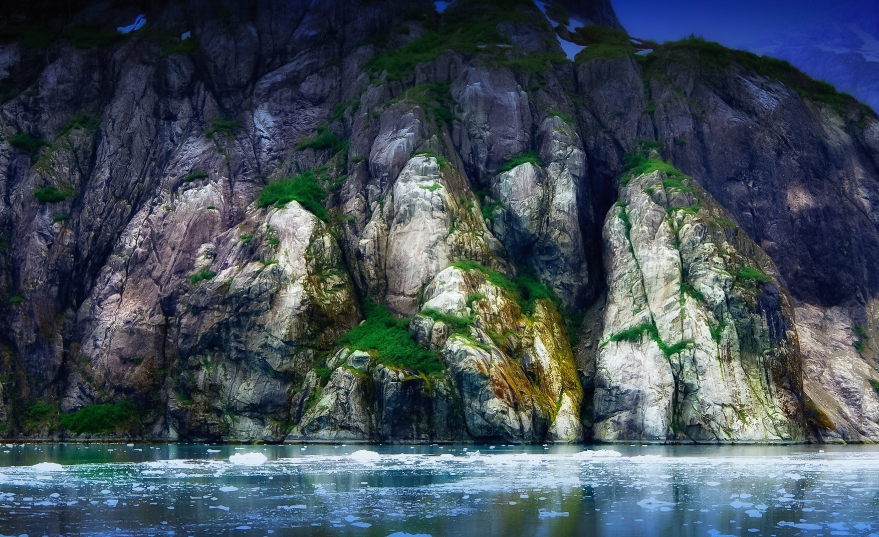 Rocky cliffs with icebergs in the water HD Wallpaper