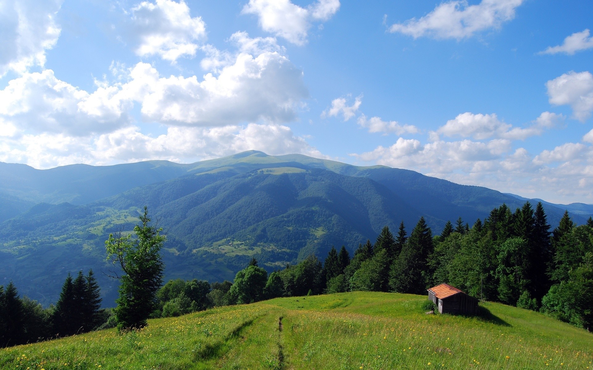 Mountain landscape with a small cabin and green hills HD Wallpaper