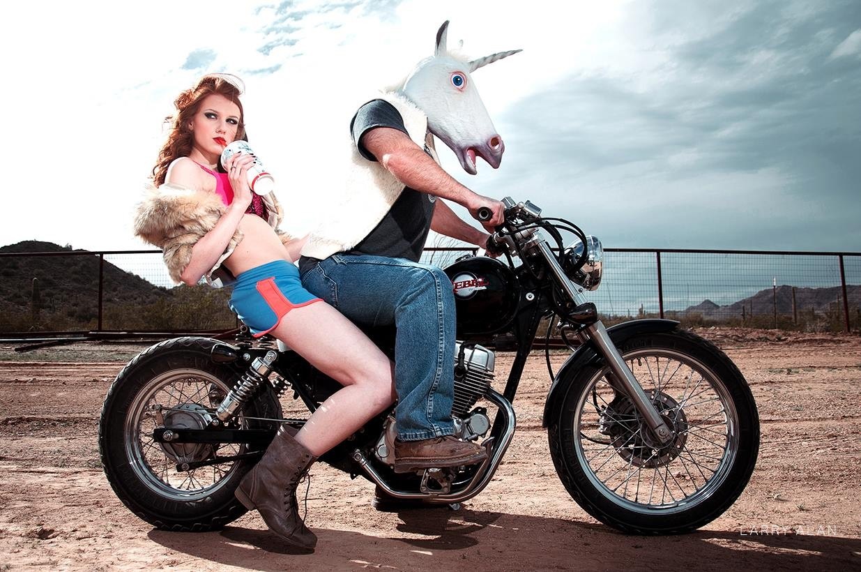 Woman and unicorn-headed person on a motorcycle HD Wallpaper