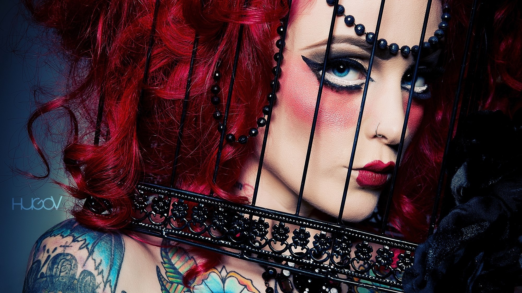 Model with red hair and tattoos behind a cage HD Wallpaper