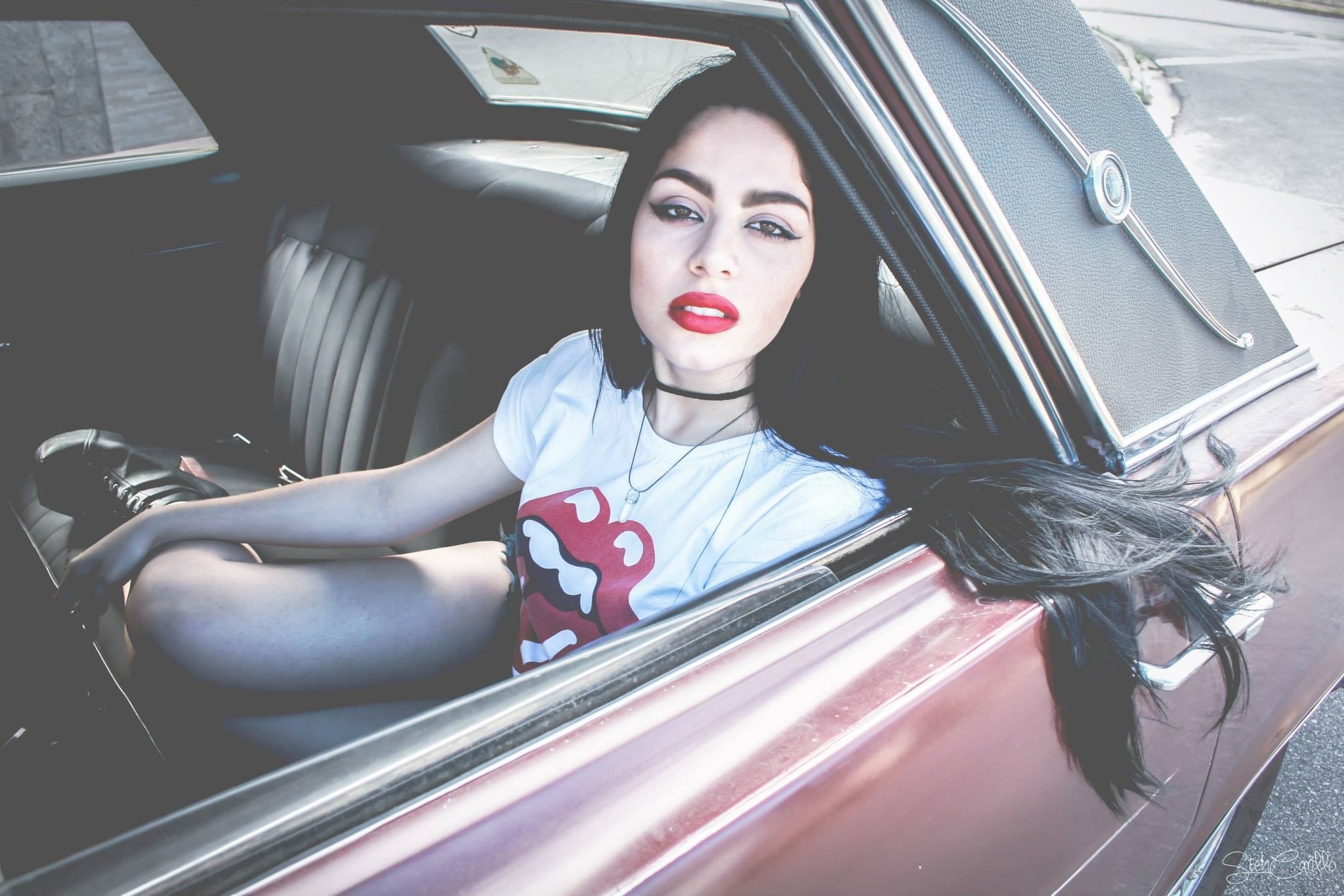 Woman with dark hair in a vintage car HD Wallpaper