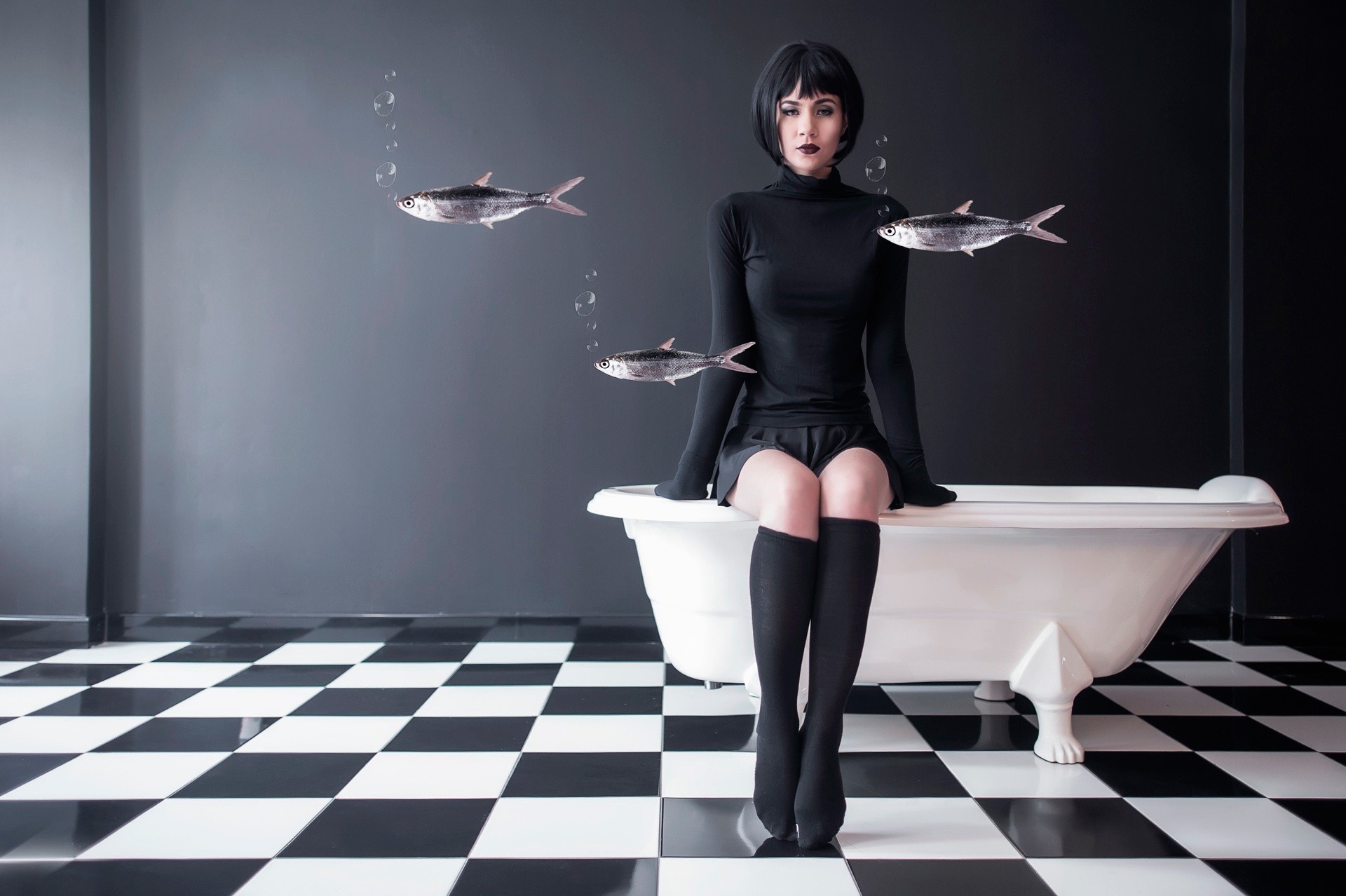 Woman in black sitting on bathtub with fish HD Wallpaper