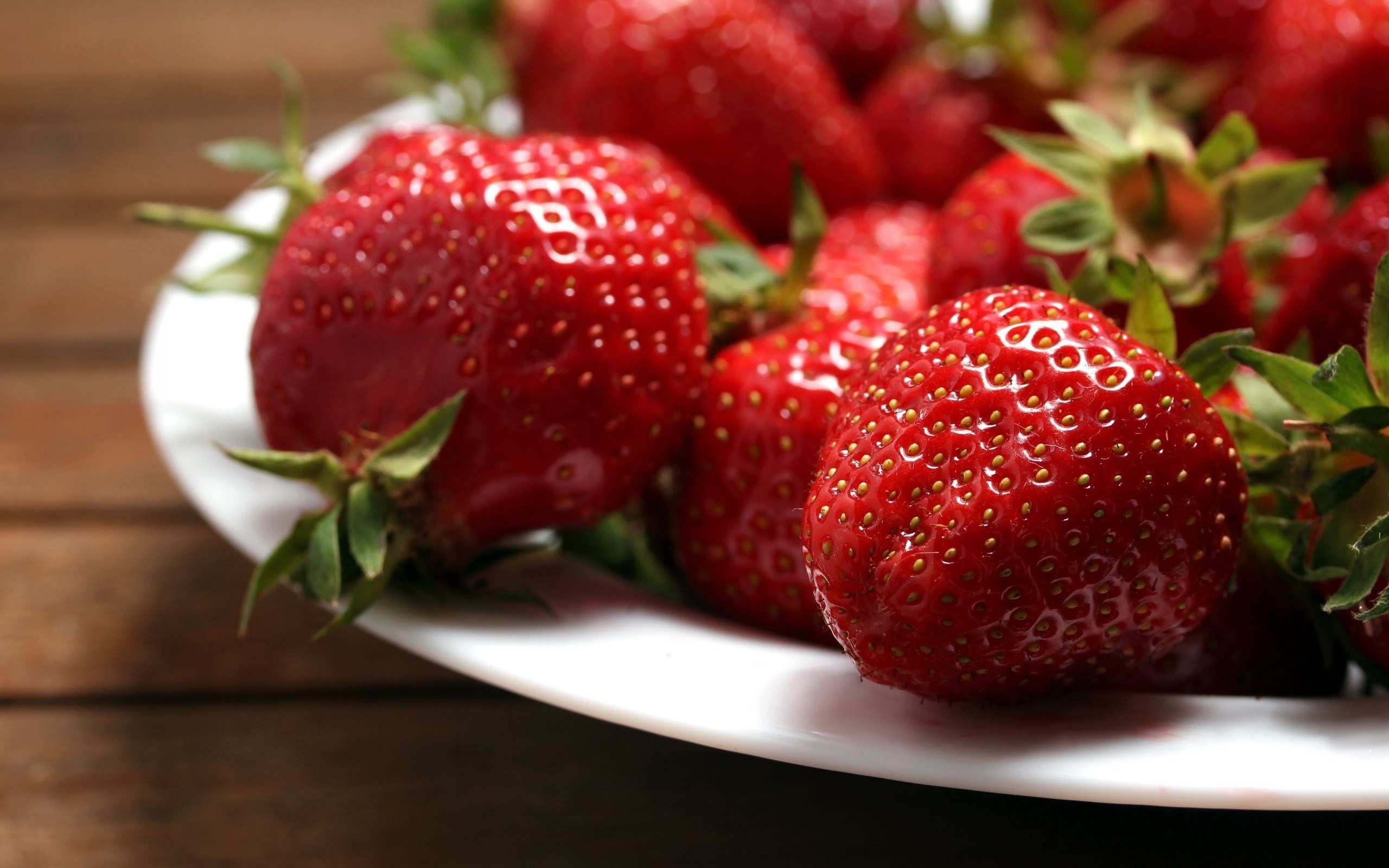 Plate of fresh strawberries on a wooden table HD Wallpaper