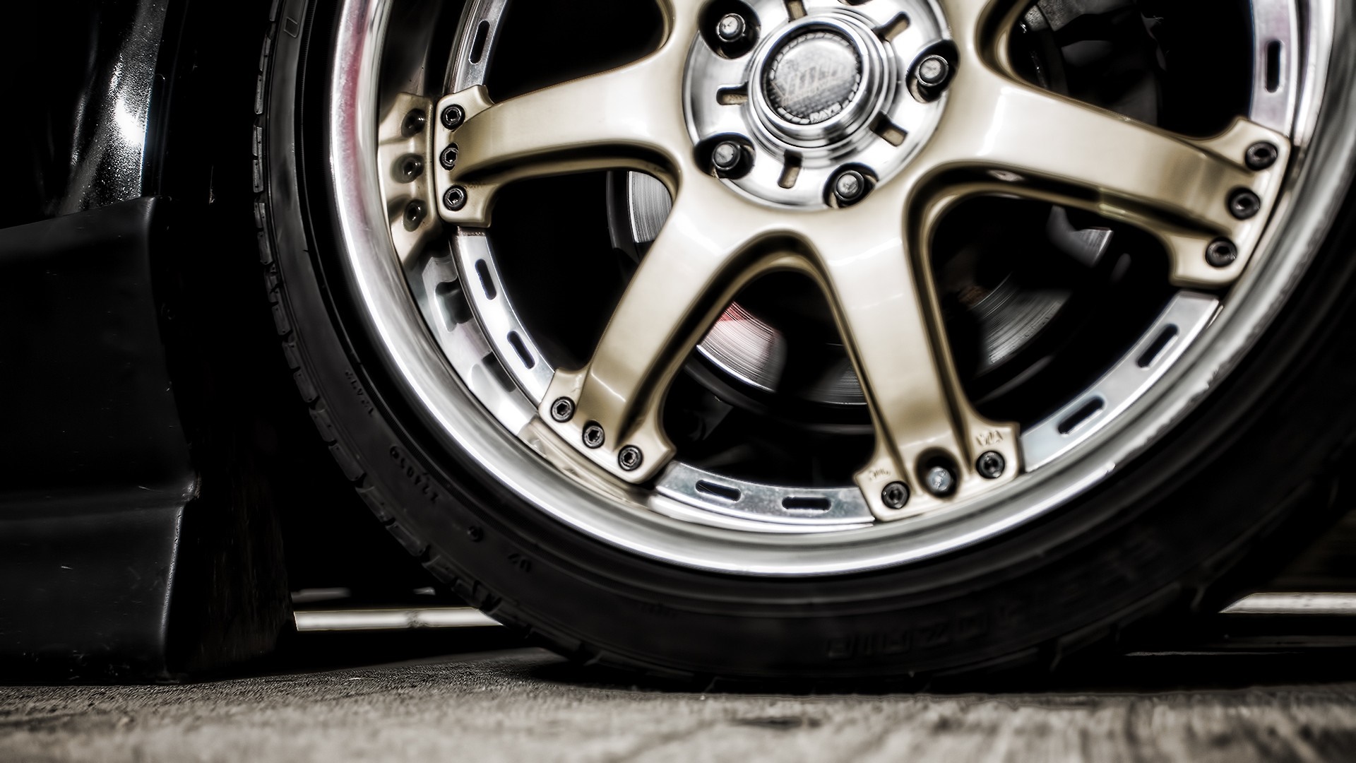 Close-up of a car's gold alloy wheel and tire HD Wallpaper
