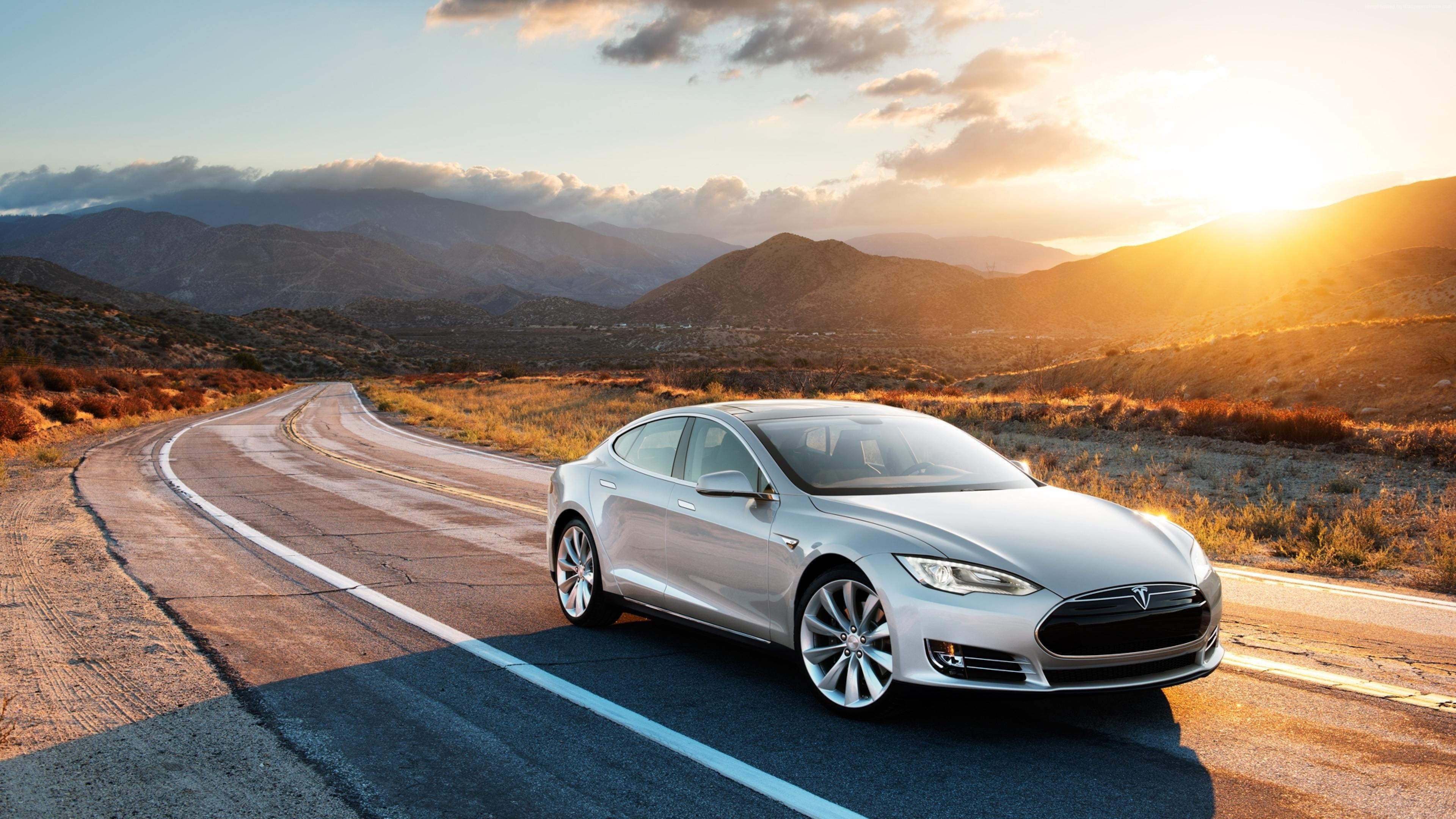 Silver Tesla Model S on a desert road at sunset HD Wallpaper