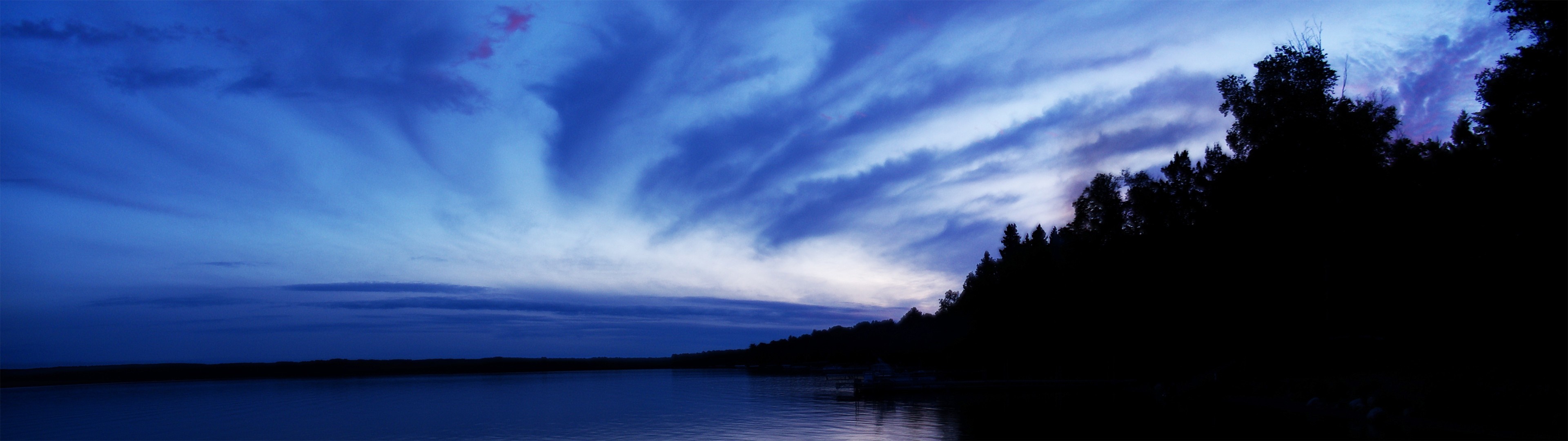 Panoramic view of a lake at dusk with silhouetted trees HD Wallpaper