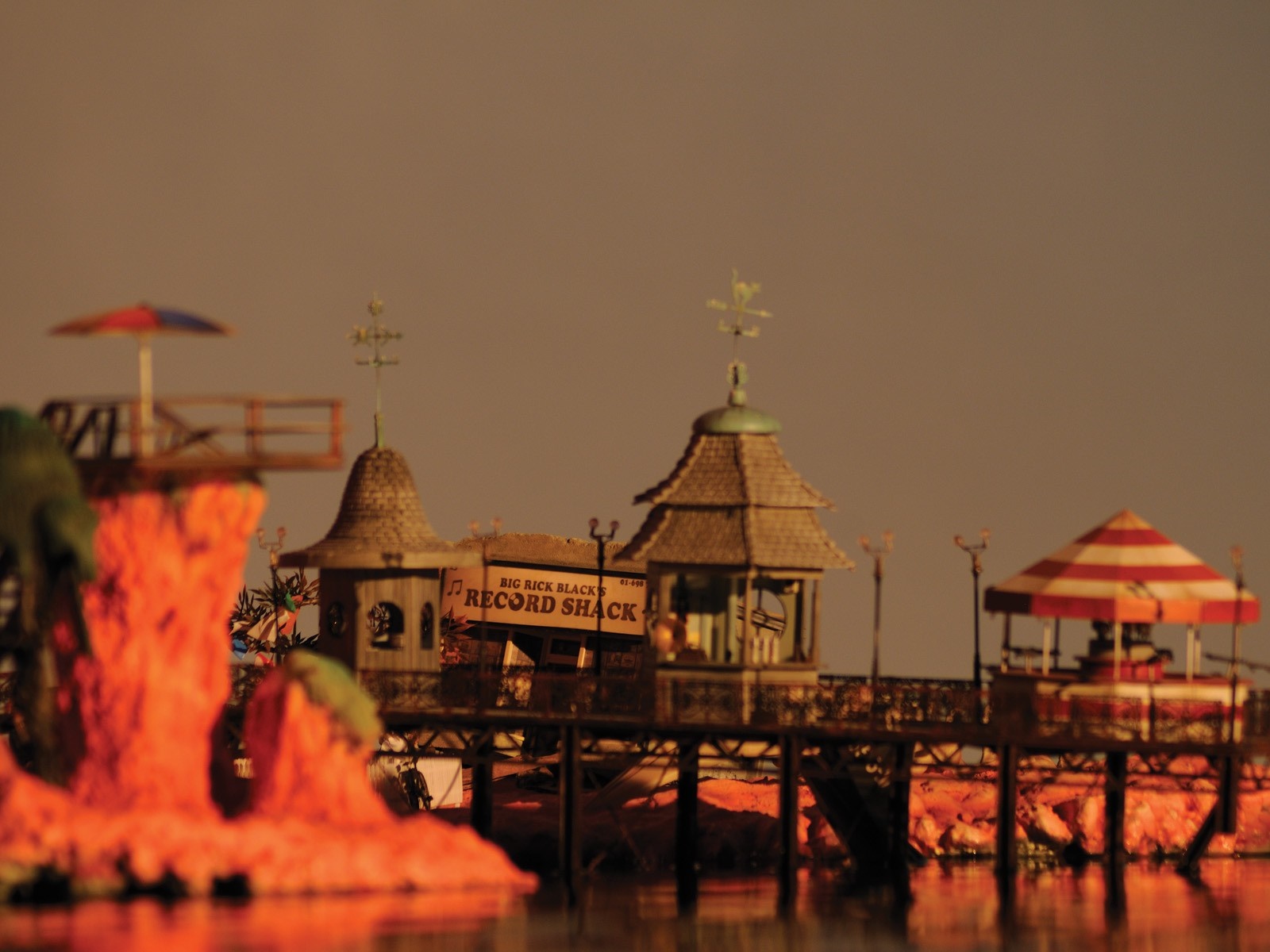 Amusement park pier with record shack and striped umbrella HD Wallpaper
