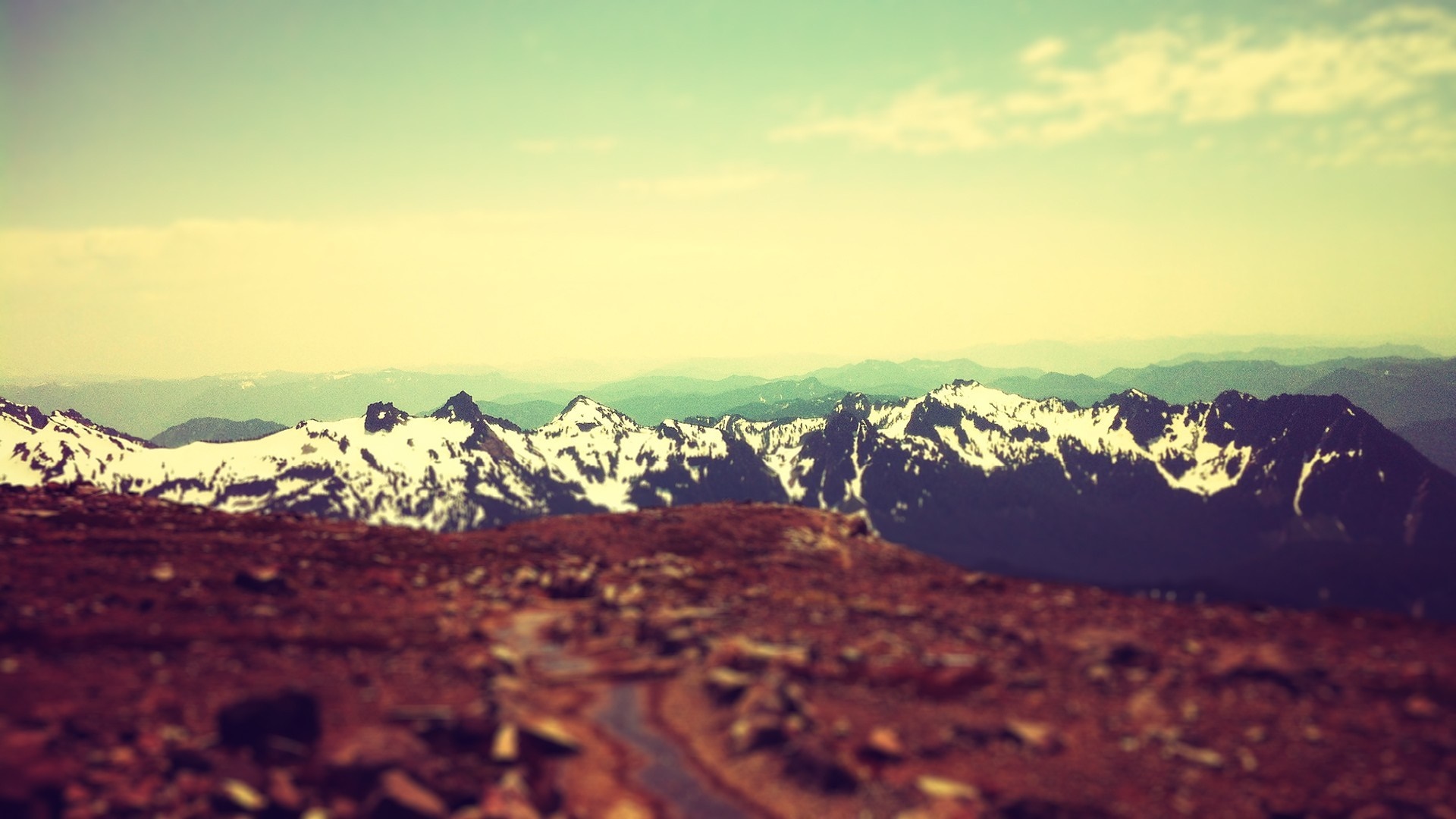 Snow-capped mountains under a hazy sky HD Wallpaper