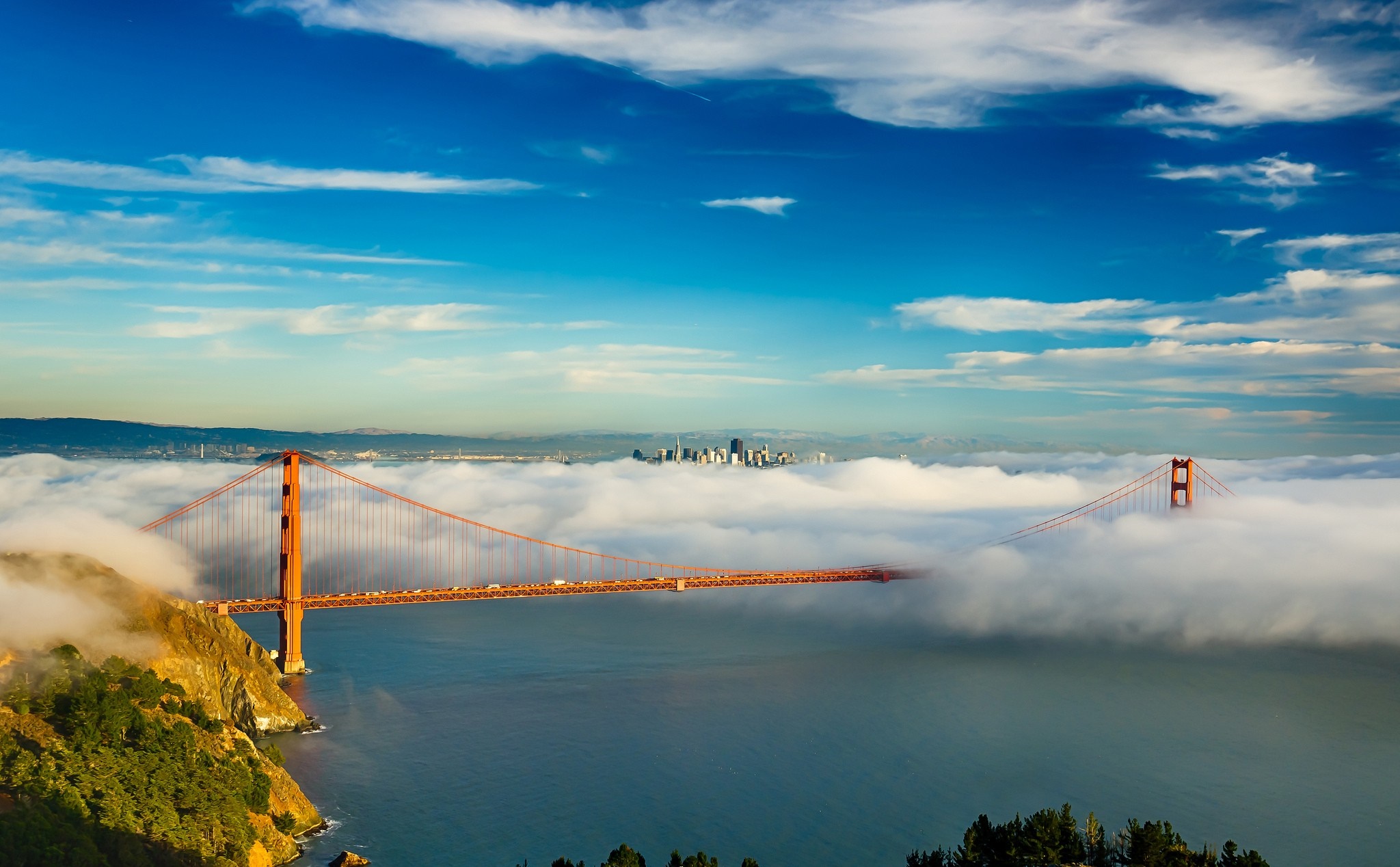 Golden Gate Bridge shrouded in fog with San Francisco skyline HD Wallpaper